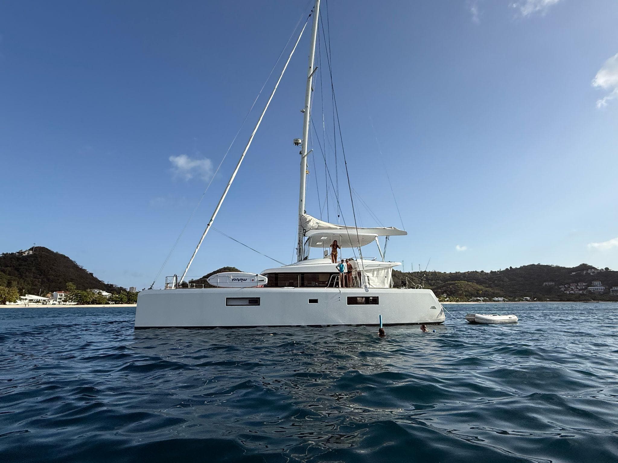 2014 Lagoon 52 F catamaran sailing near scenic coastline.