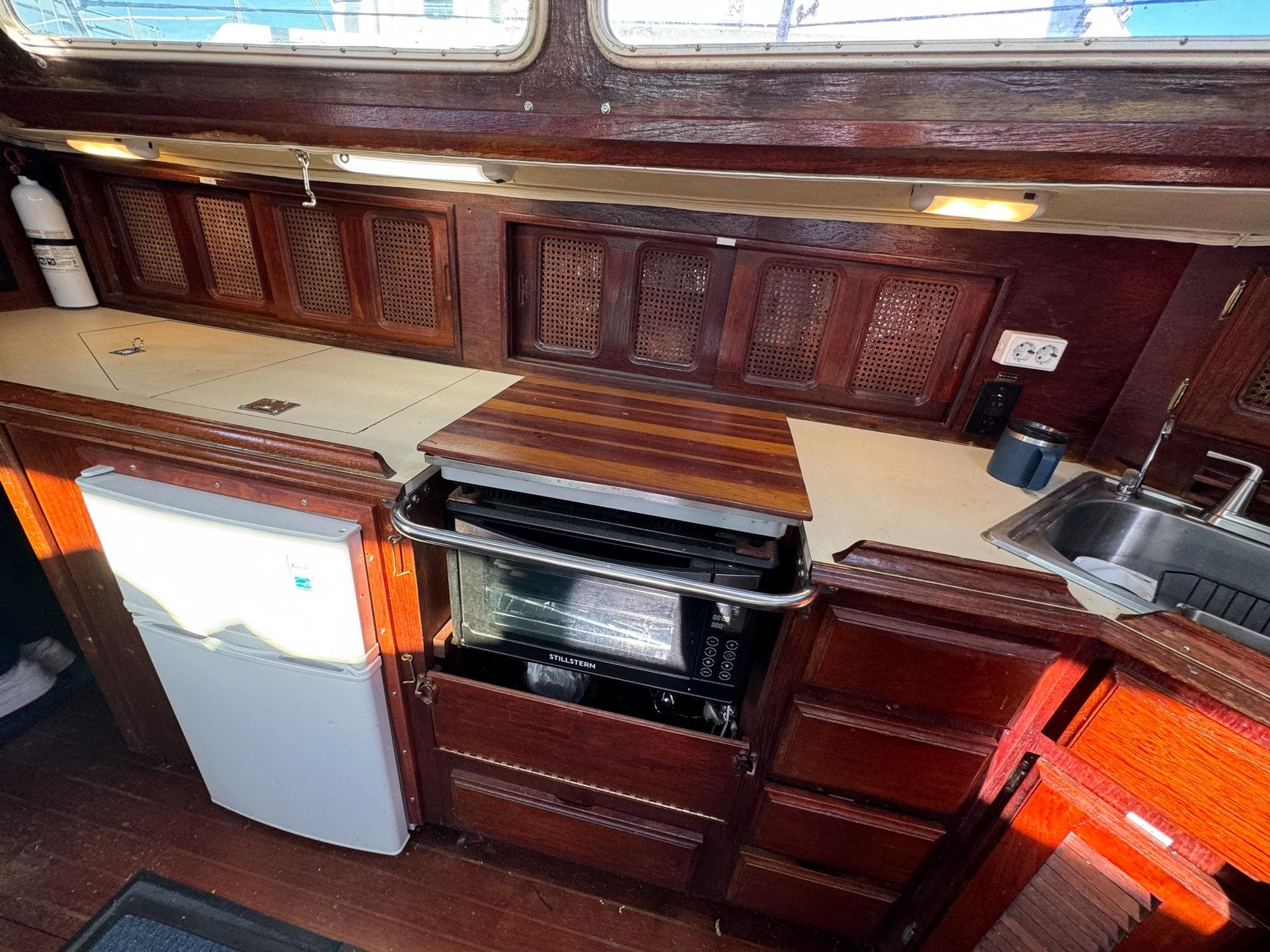 1983 Islander Freeport yacht kitchen with wood cabinetry, stove, and sink.
