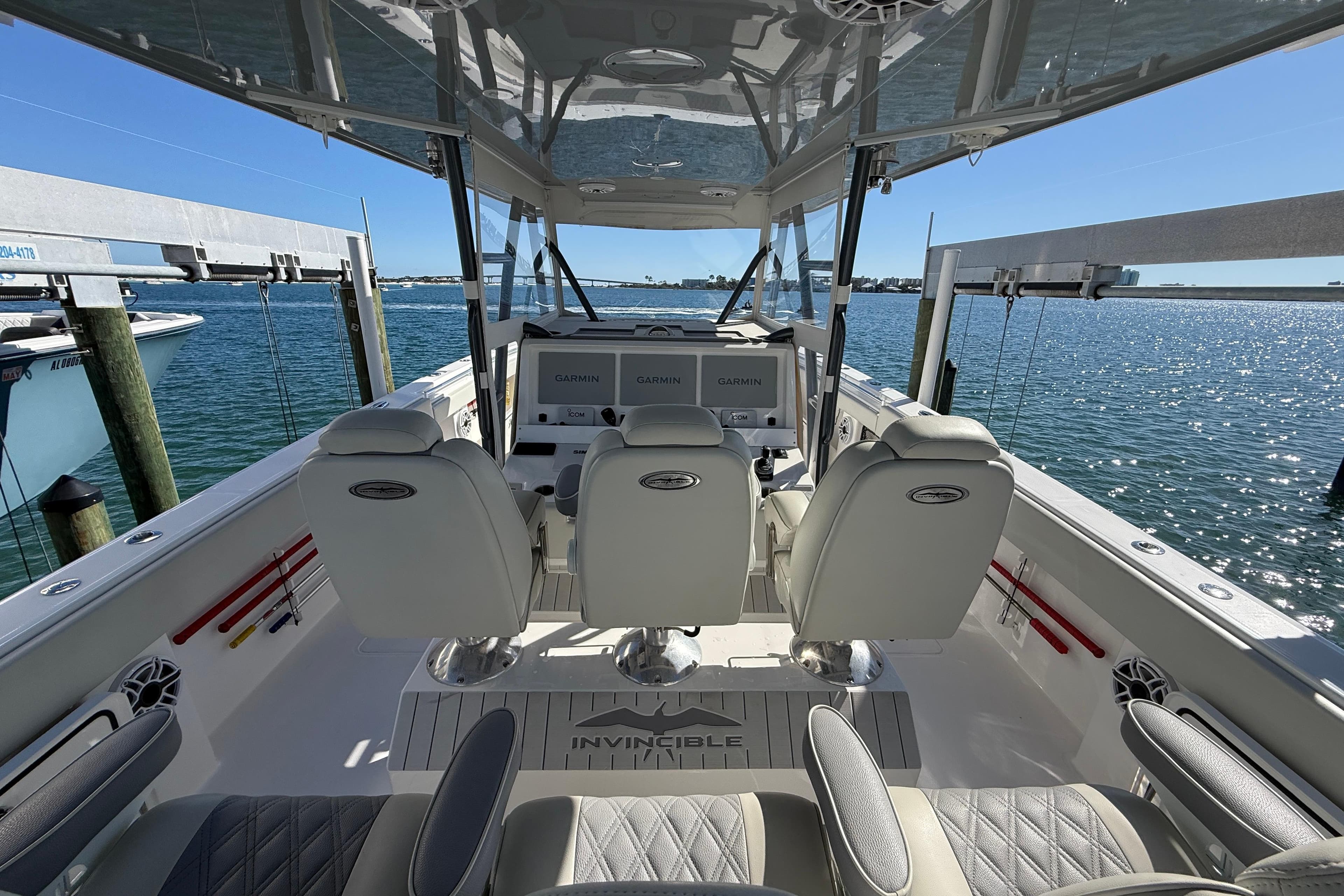 Interior view of 2022 Invincible 40 Catamaran with helm and seating, docked by the water.