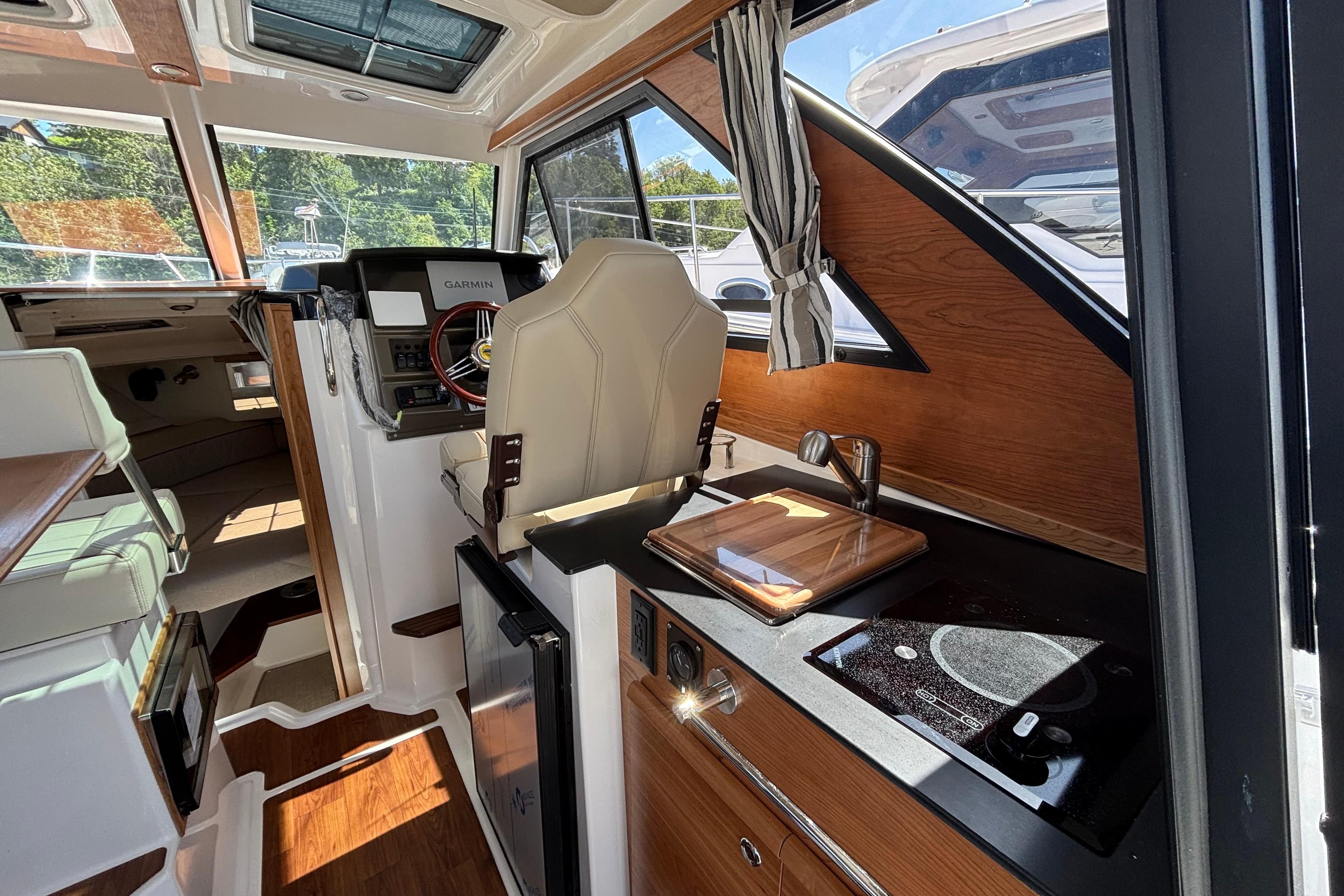 Interior of 2026 Cutwater C-248 Coupe featuring helm, kitchenette, and seating area.