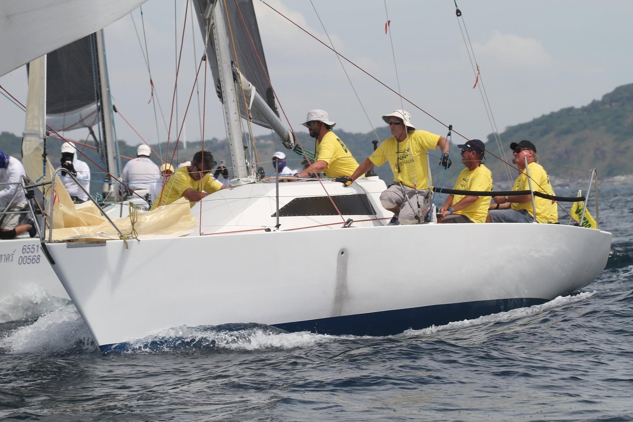 Sailing crew on 1986 3/4 Tonner yacht racing in open waters.
