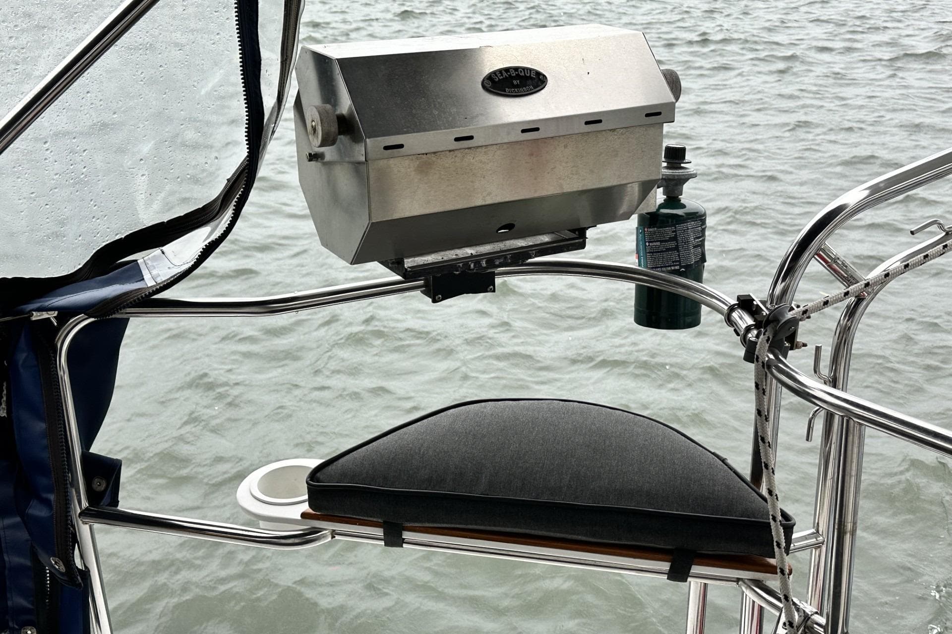 Outdoor grill setup on a 2002 Hunter 466 sailboat, overlooking water.