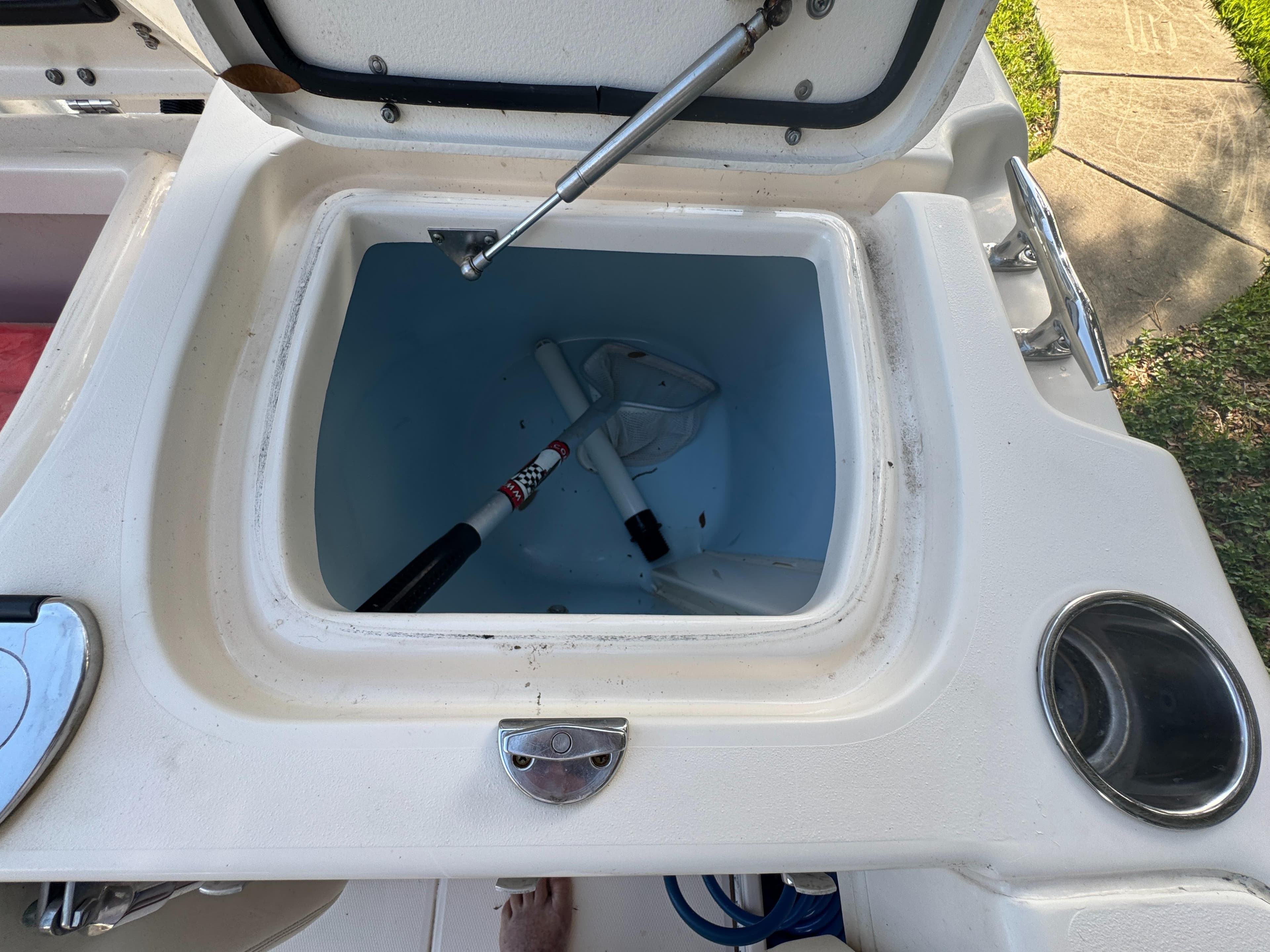 Open storage compartment on 2017 Grady-White Fisherman 257 boat, containing a white paddle.