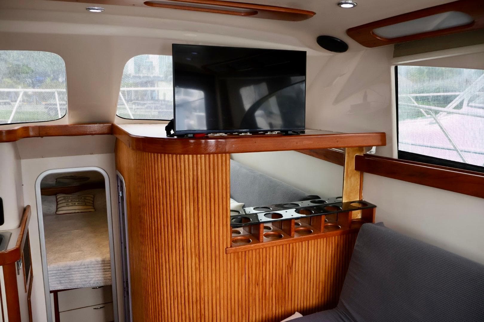 Interior of 1994 Luhrs 32 Convertible yacht with TV and wooden cabinetry.