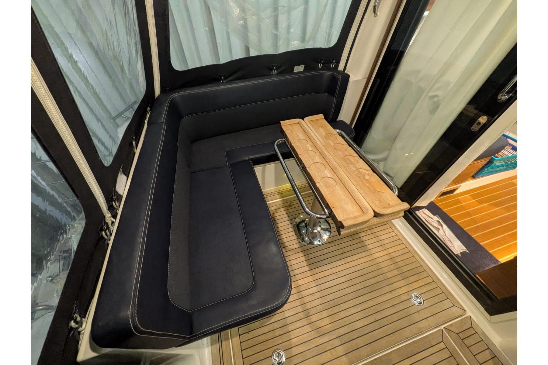 Interior of 2016 Nimbus Boats 305 Coupé with black seating and wooden table.