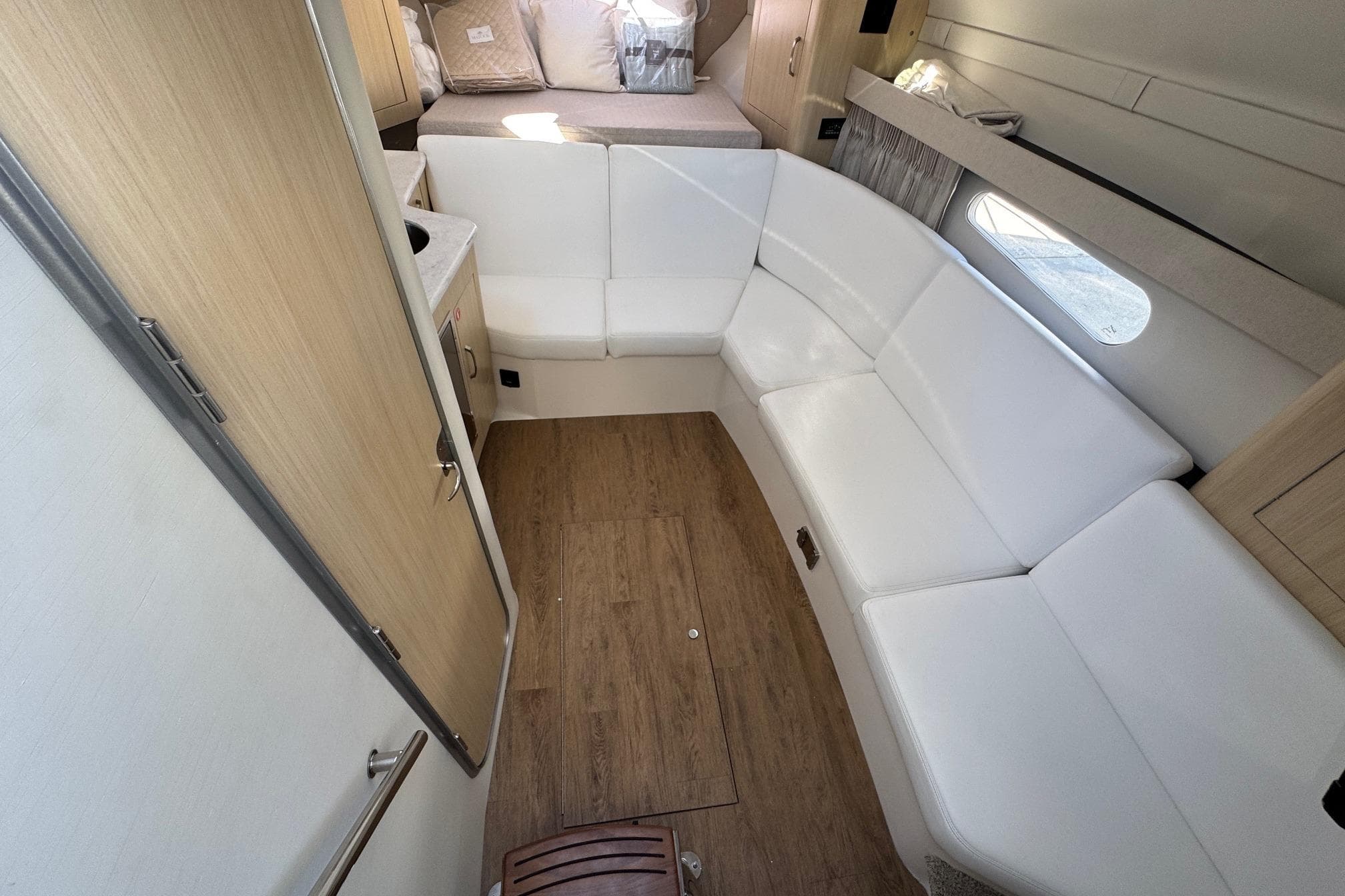 2026 Regal 33 XO yacht interior with white seating and wood flooring.