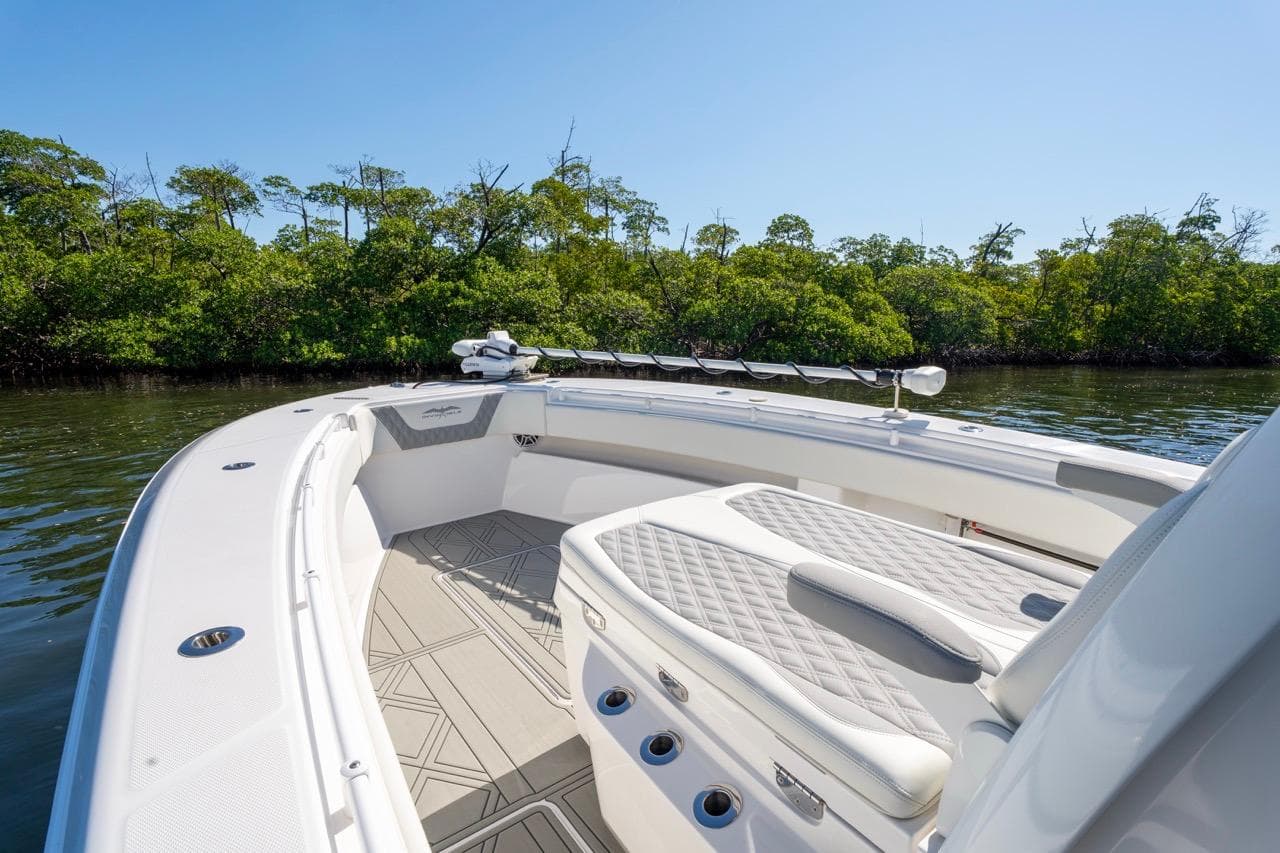 2025 Invincible 33 Open Fisherman boat with sleek seating, cruising near lush mangroves.