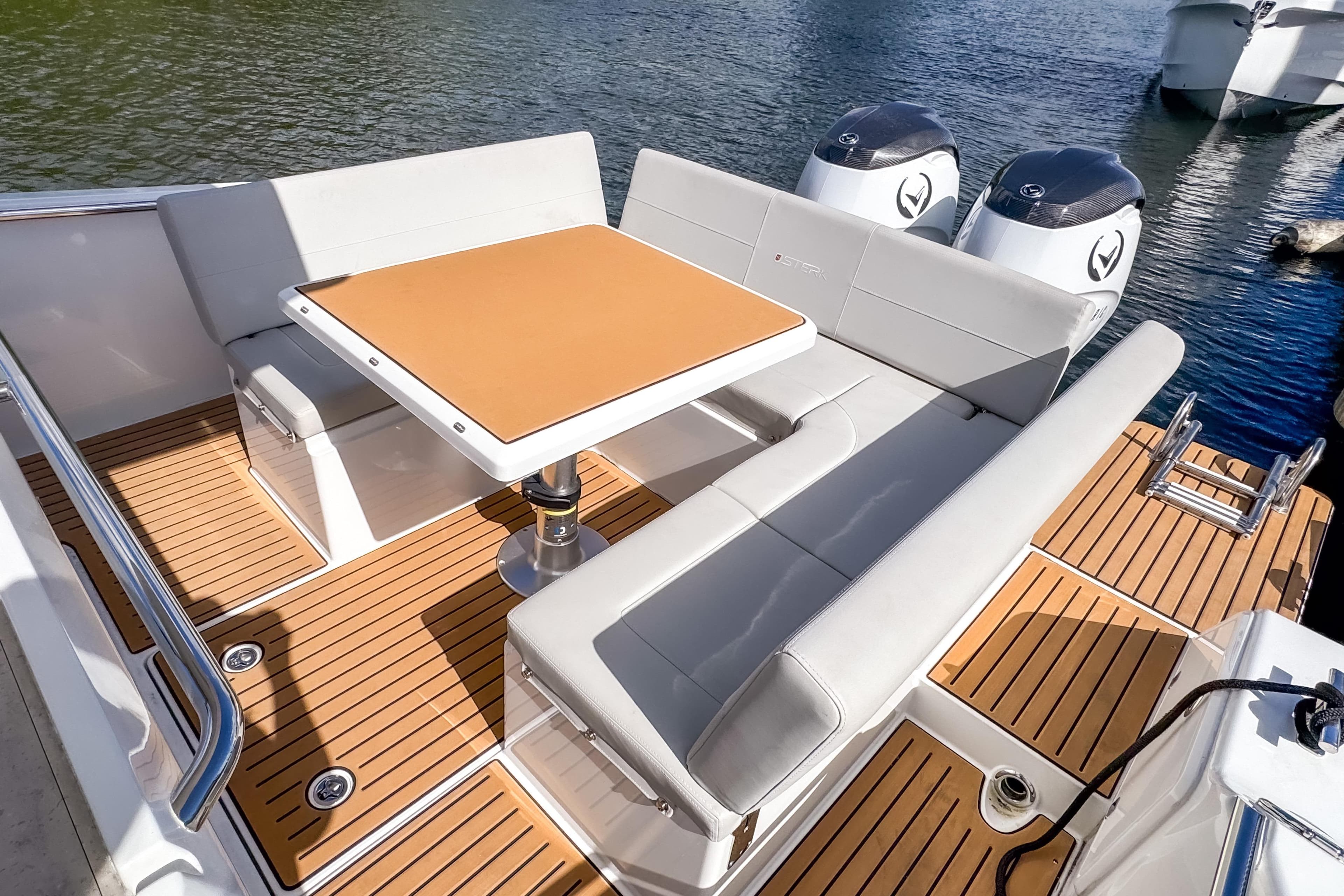 Luxurious 2025 STERK 31 boat interior with elegant seating and table on deck.