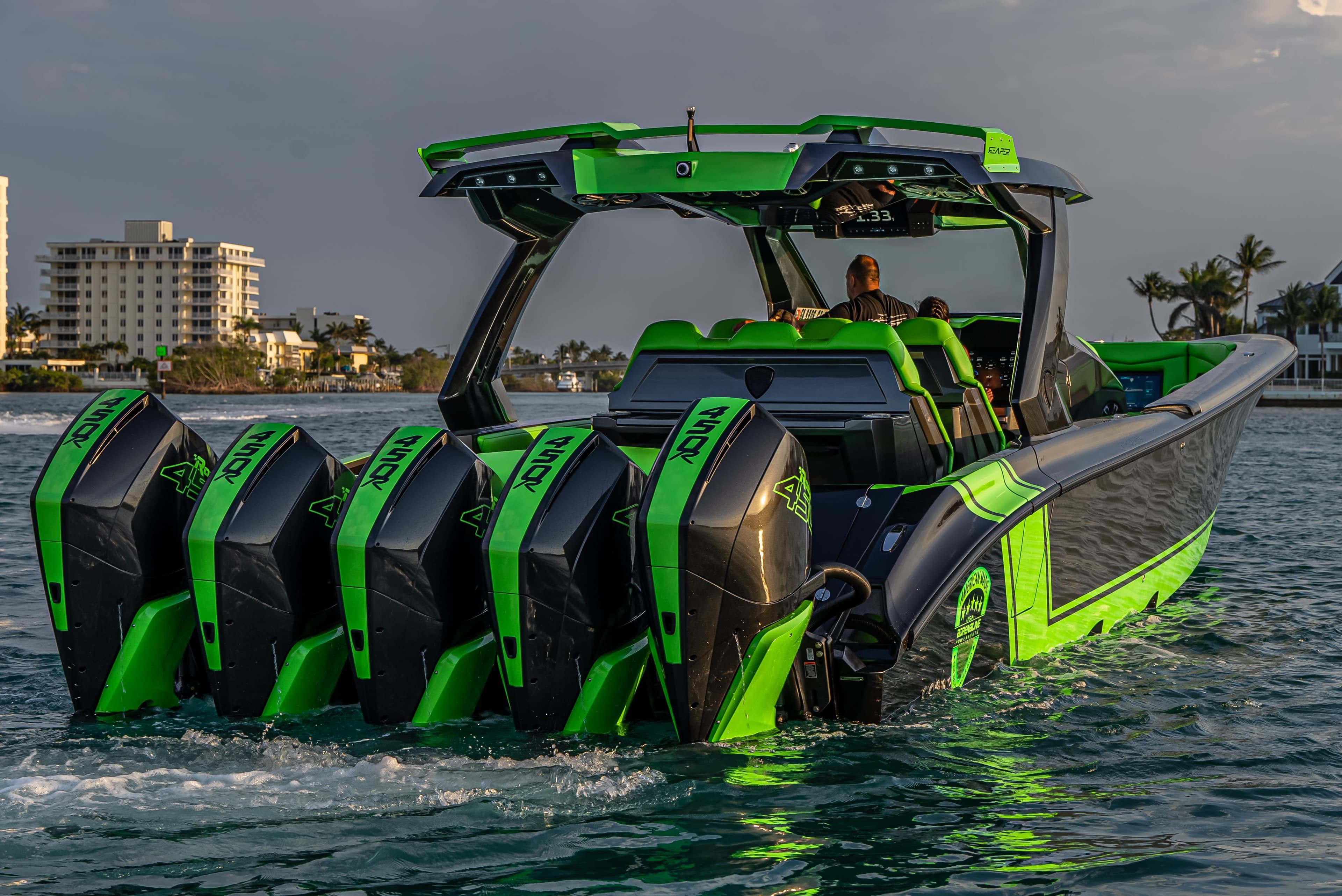 2024 Adrenaline Reaper boat with five powerful engines, cruising near a coastal cityscape.