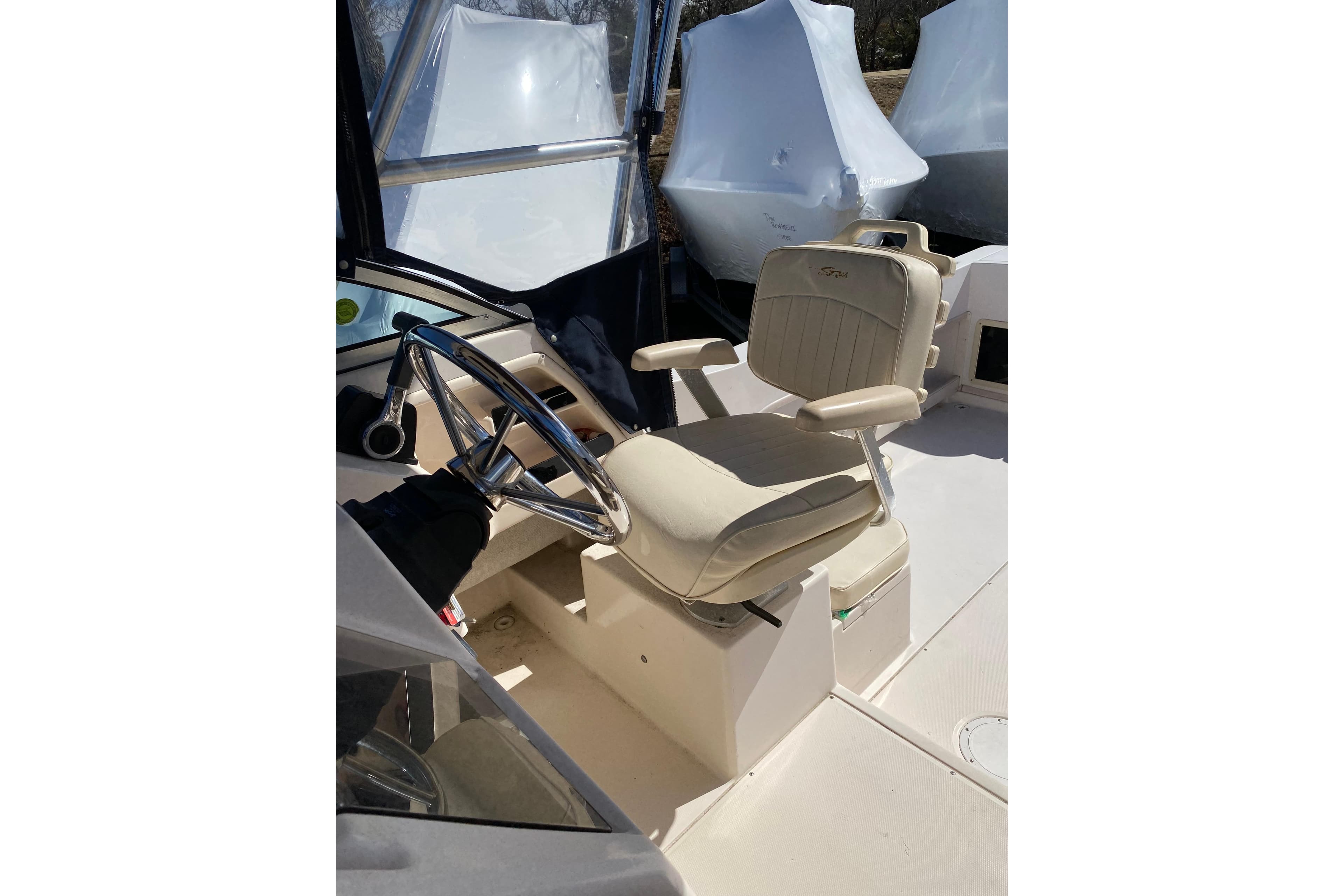 2001 Grady-White Gulfstream 232 boat helm with beige captain's chair and steering wheel.