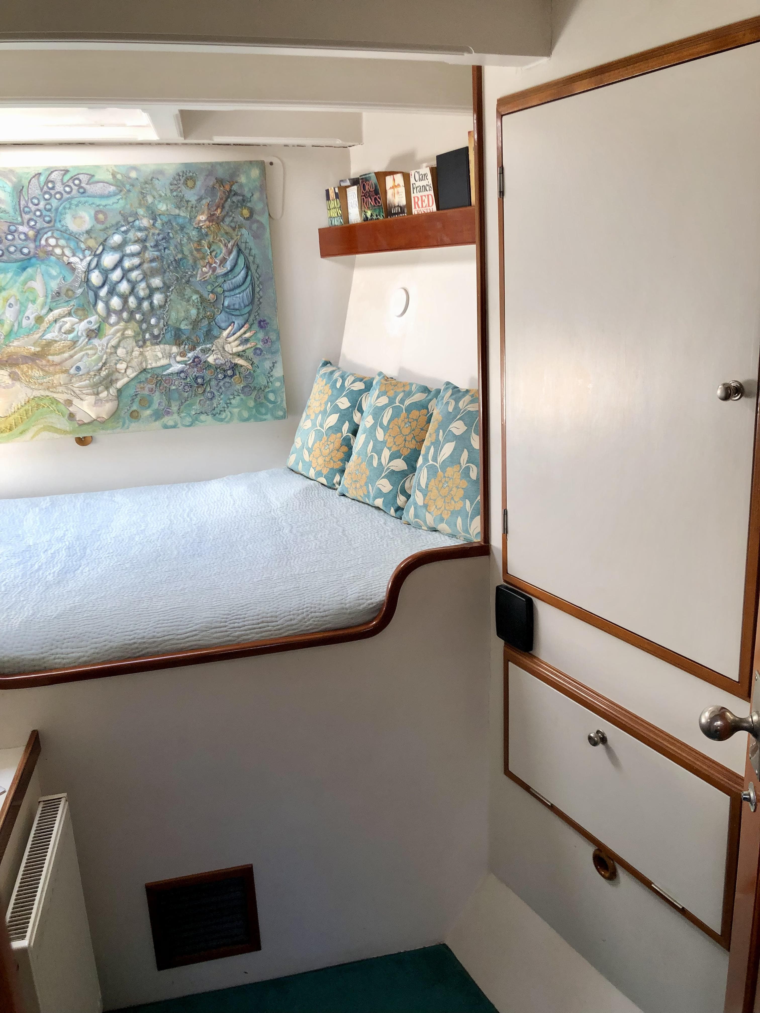 Cozy cabin interior of 2012 Classic 65ft Ketch Pilot House with colorful decor and bedding.