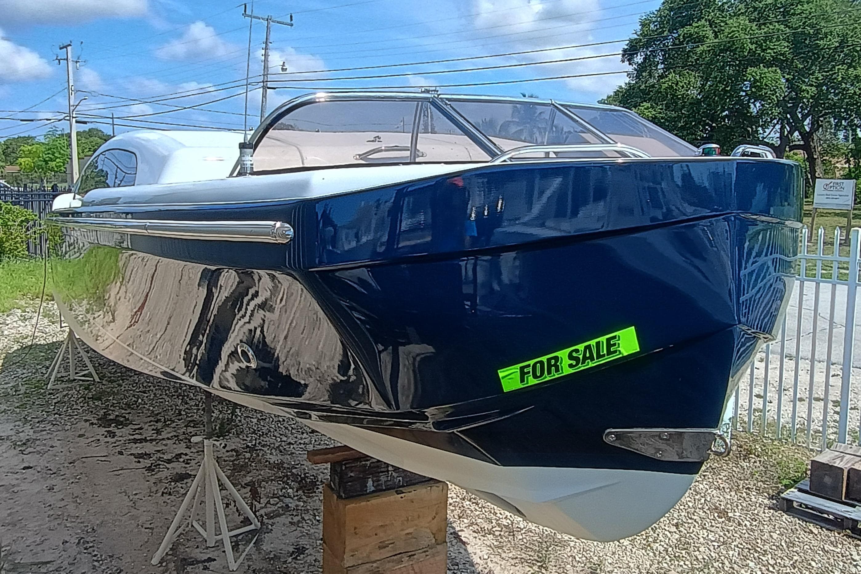 2006 Royal Denship Royal Limo boat for sale, sleek design, blue exterior, parked outdoors.