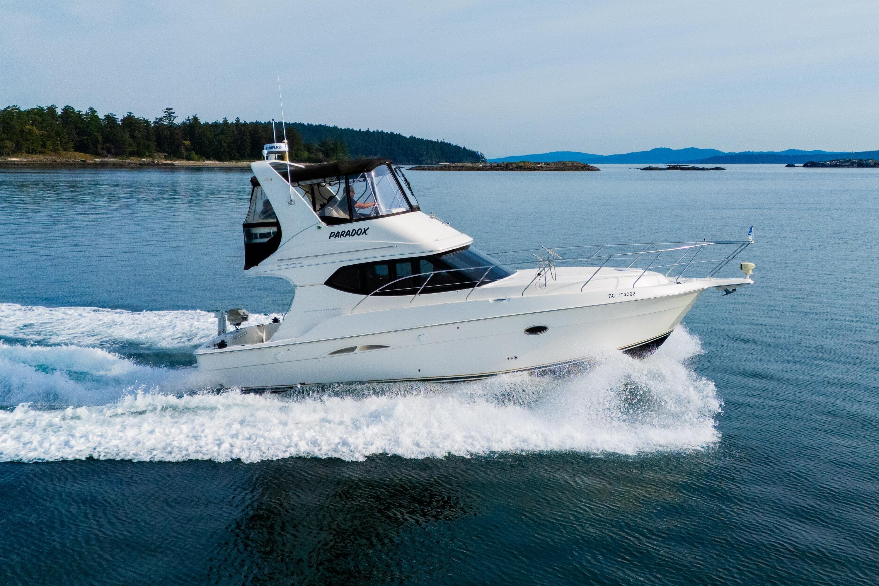 2005 Silverton 34 Convertible yacht cruising on calm waters.