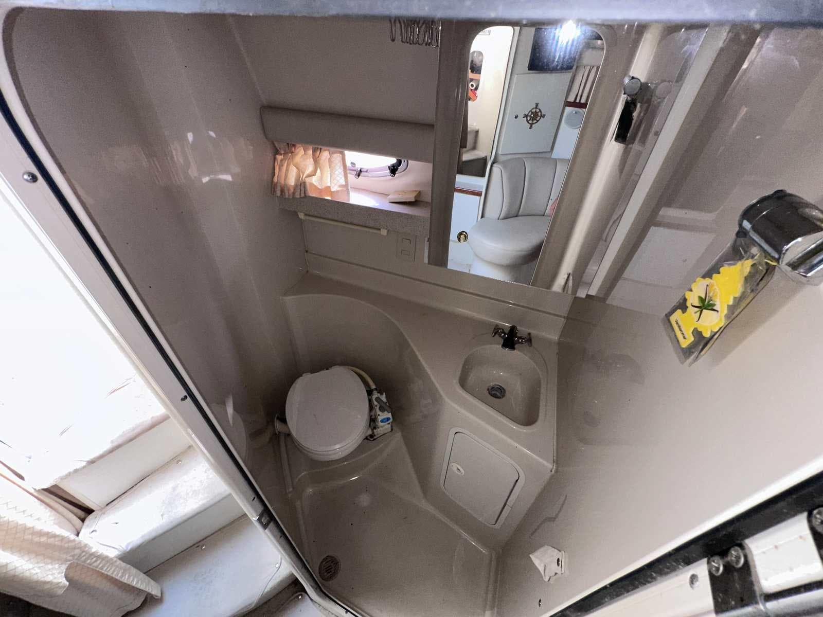 1998 Cruisers Yachts 3075 Rogue bathroom with toilet, sink, and mirror.