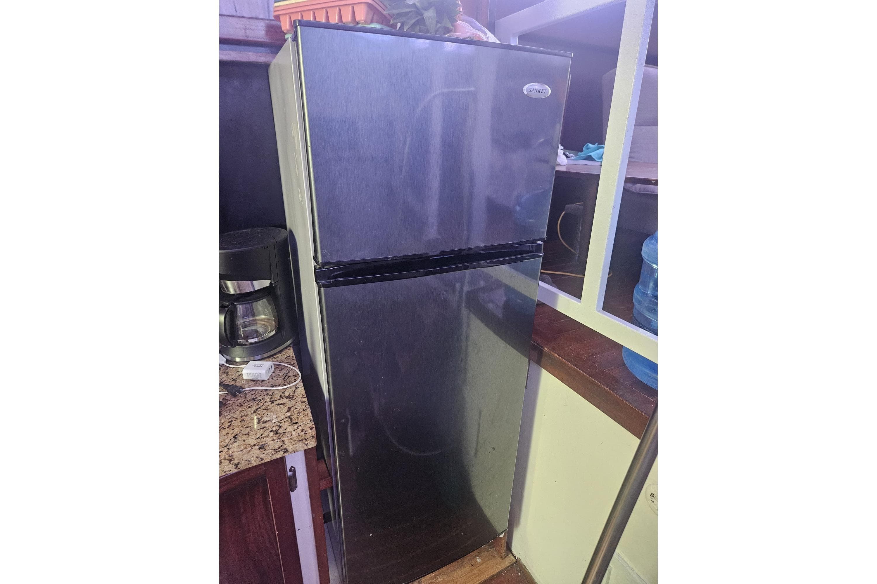Stainless steel refrigerator in a 1977 Chris-Craft 52 Constellation yacht kitchen.