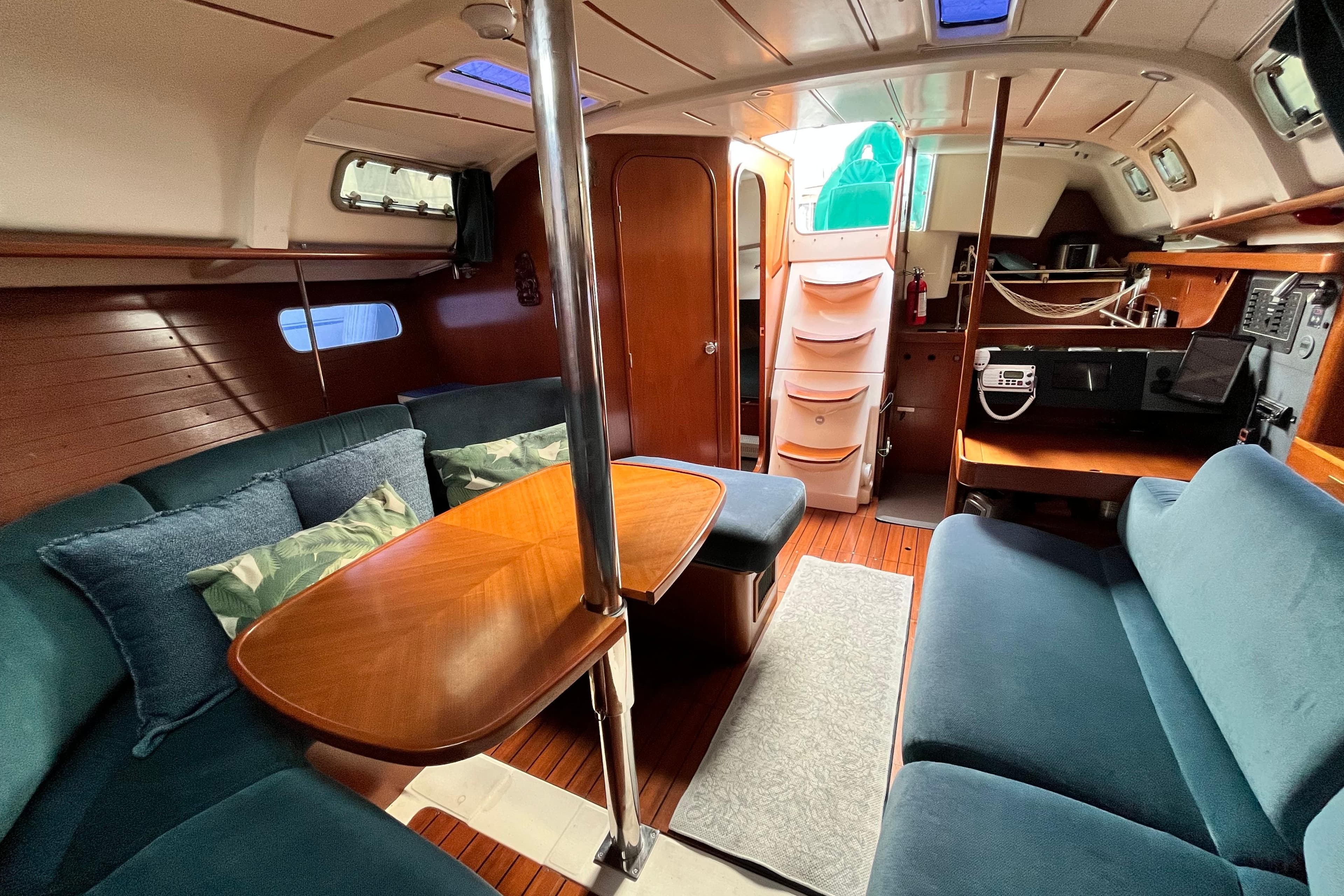 Interior of 1995 Beneteau Oceanis 351 sailboat with cozy seating and wooden finishes.