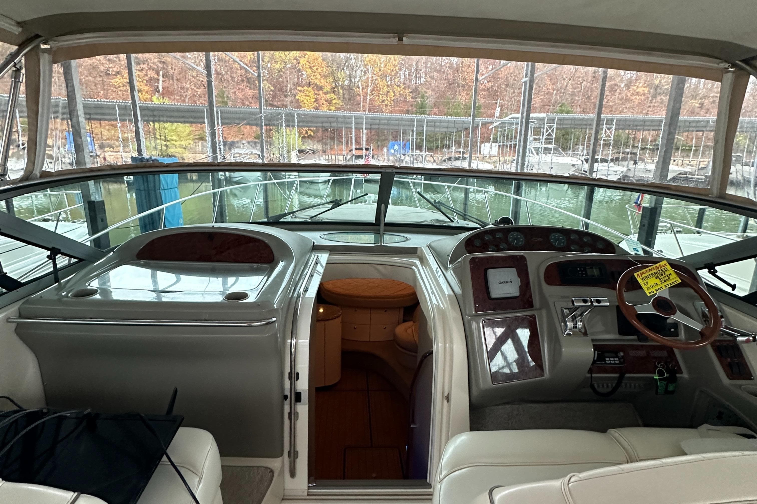 Interior view of 1998 Maxum 3700 SCR yacht cockpit with steering wheel and controls.