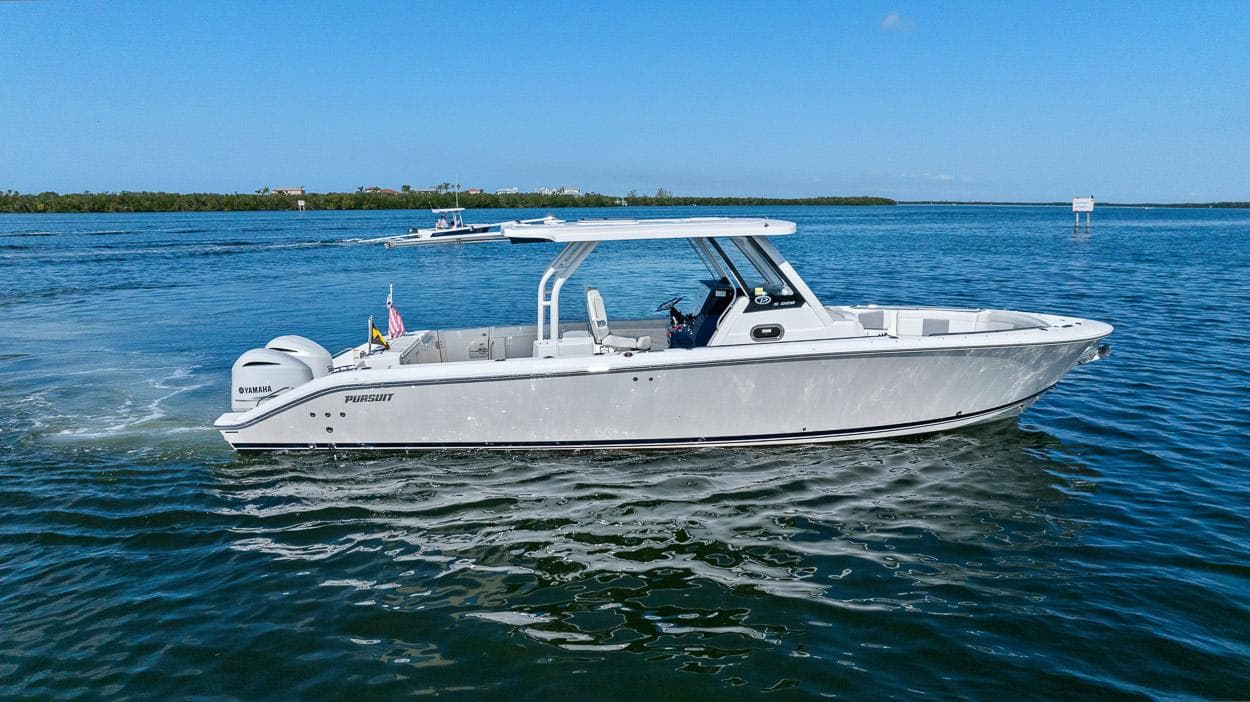2021 Pursuit S 328 Sport boat cruising on a calm, scenic waterway.