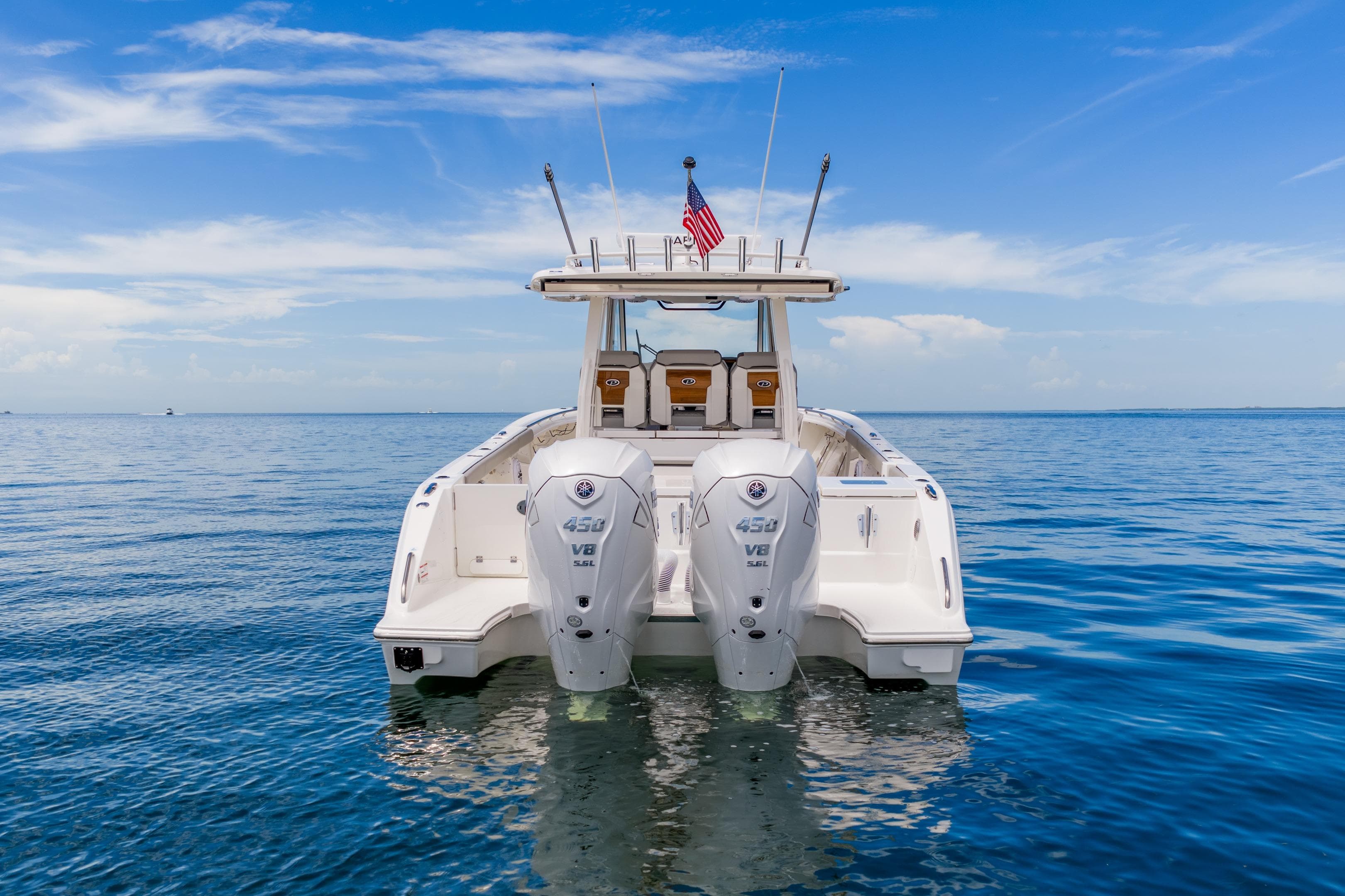 2026 Pursuit S 358 Sport boat with dual engines on calm ocean water.