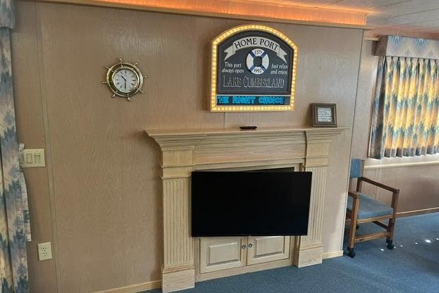 1992 Lakeview Houseboat interior with fireplace, wall clock, and decorative sign above.