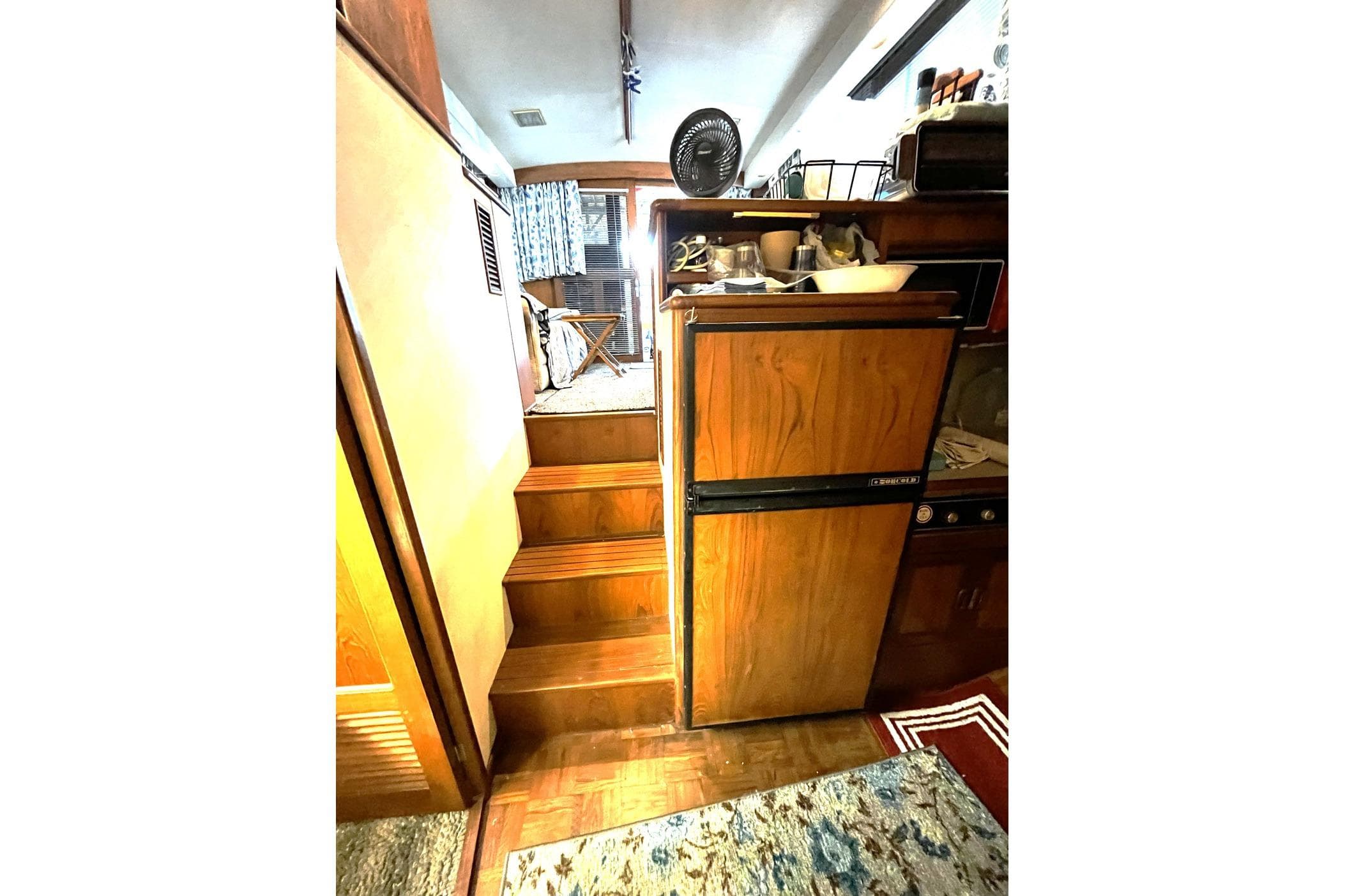 Interior of a 1991 Pace 36 RV with wooden cabinetry and compact kitchen area.