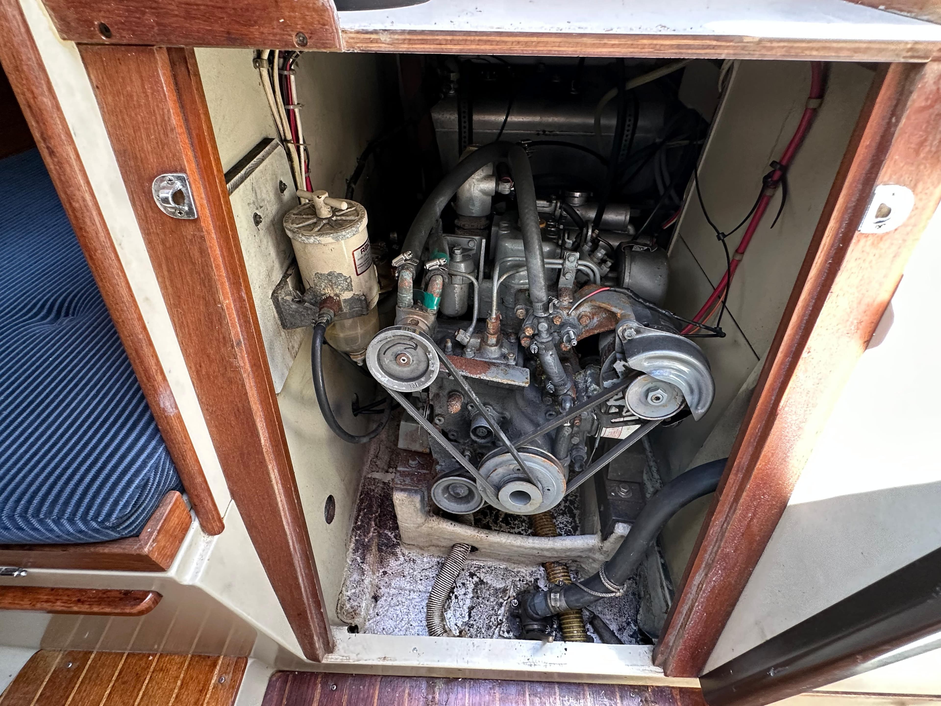 Engine compartment of a 1982 C&C 32 sailboat, showing belts and hoses.