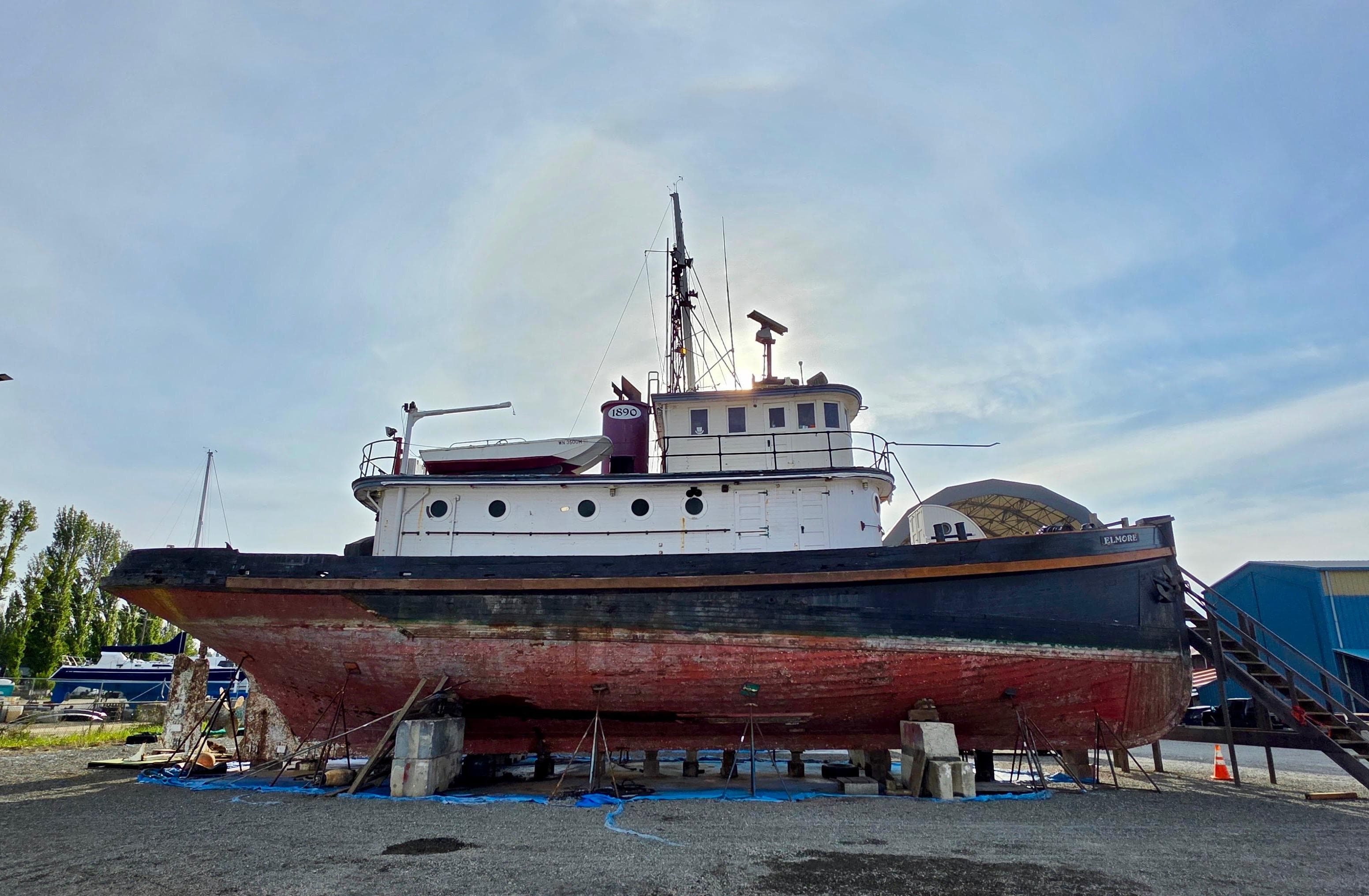Historic 1890 custom tugboat on dry dock, showcasing vintage maritime design.