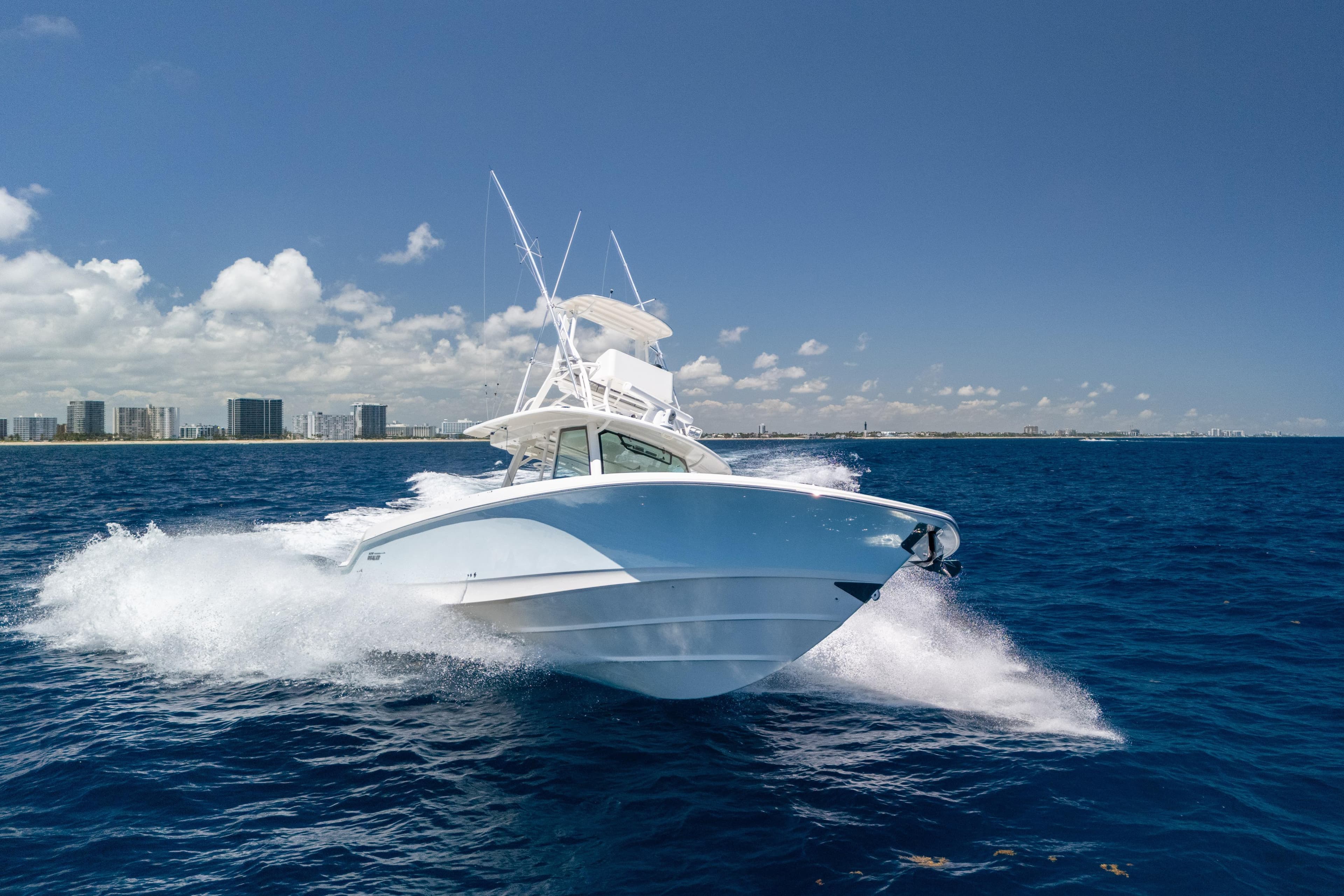 2020 Boston Whaler 380 Outrage cruising on open ocean under clear blue sky.