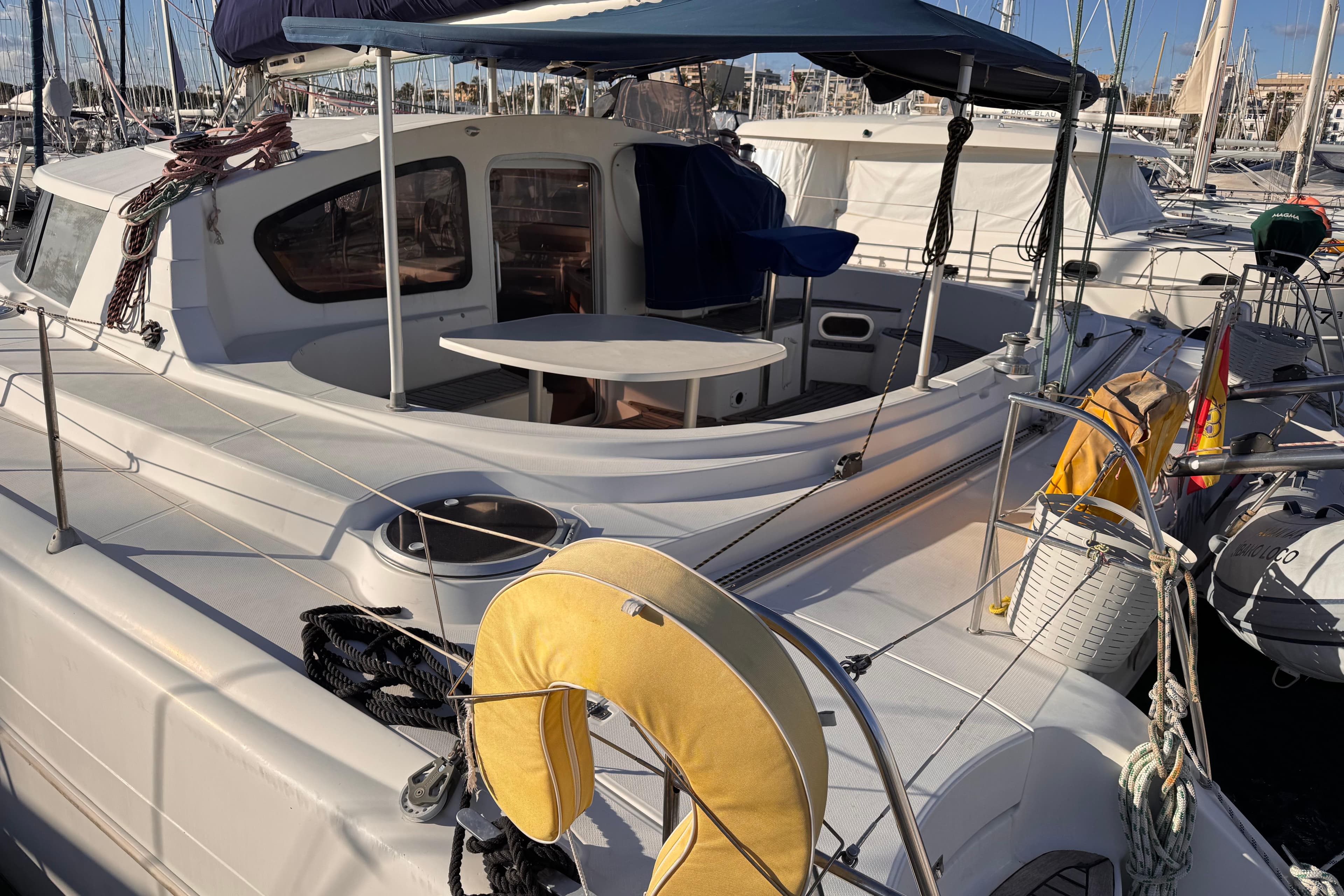 2003 Fountaine Pajot Belize 43 catamaran docked, featuring spacious deck and seating area.