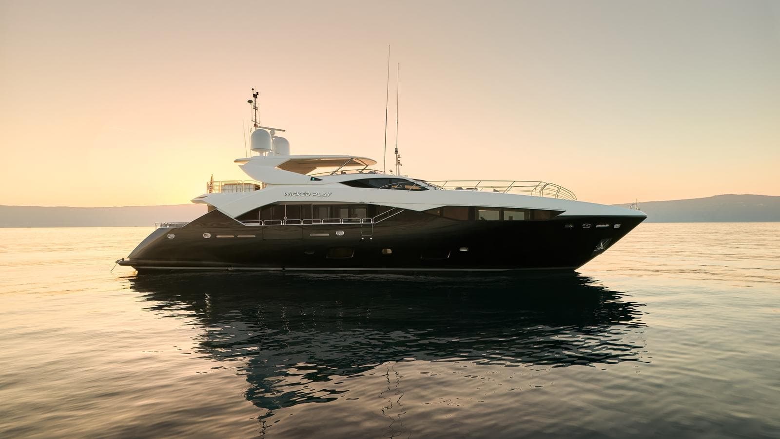 2015 Sunseeker 115 Sport Yacht on calm water at sunset.