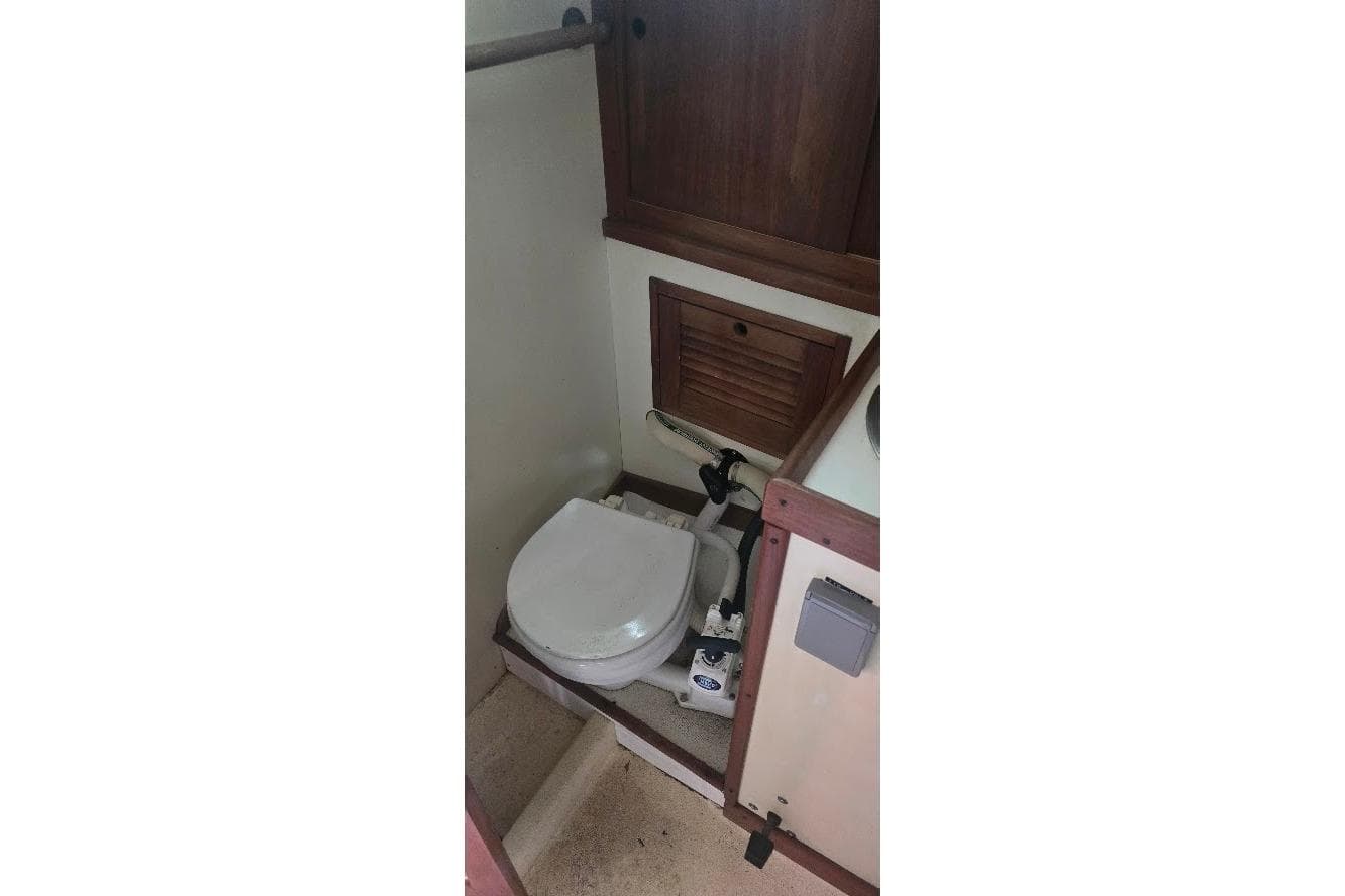 1978 Tartan T34c sailboat bathroom with wooden cabinetry and compact toilet.