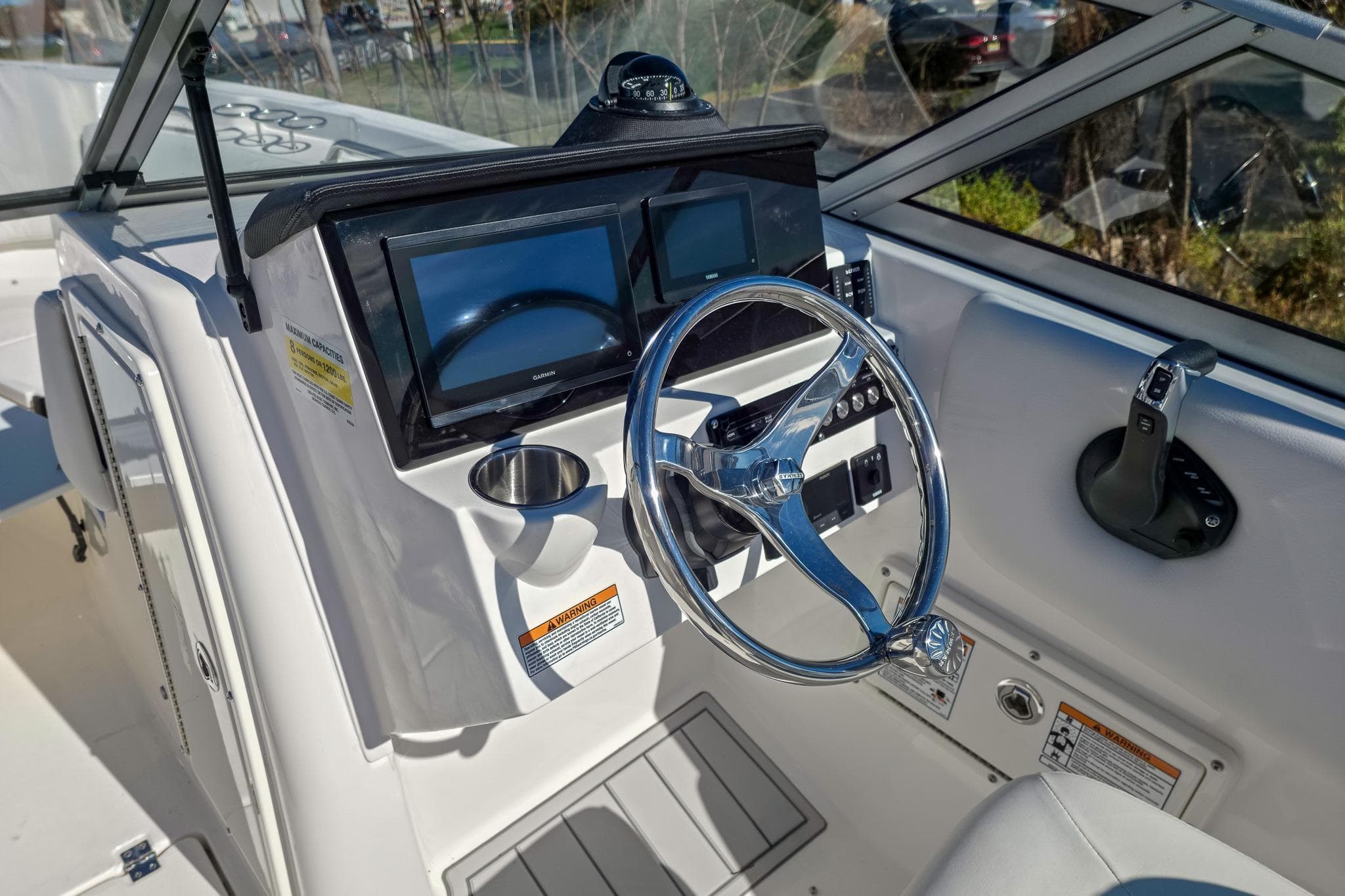 2026 Sea Fox 228 Traveler boat dashboard with steering wheel and navigation screens.