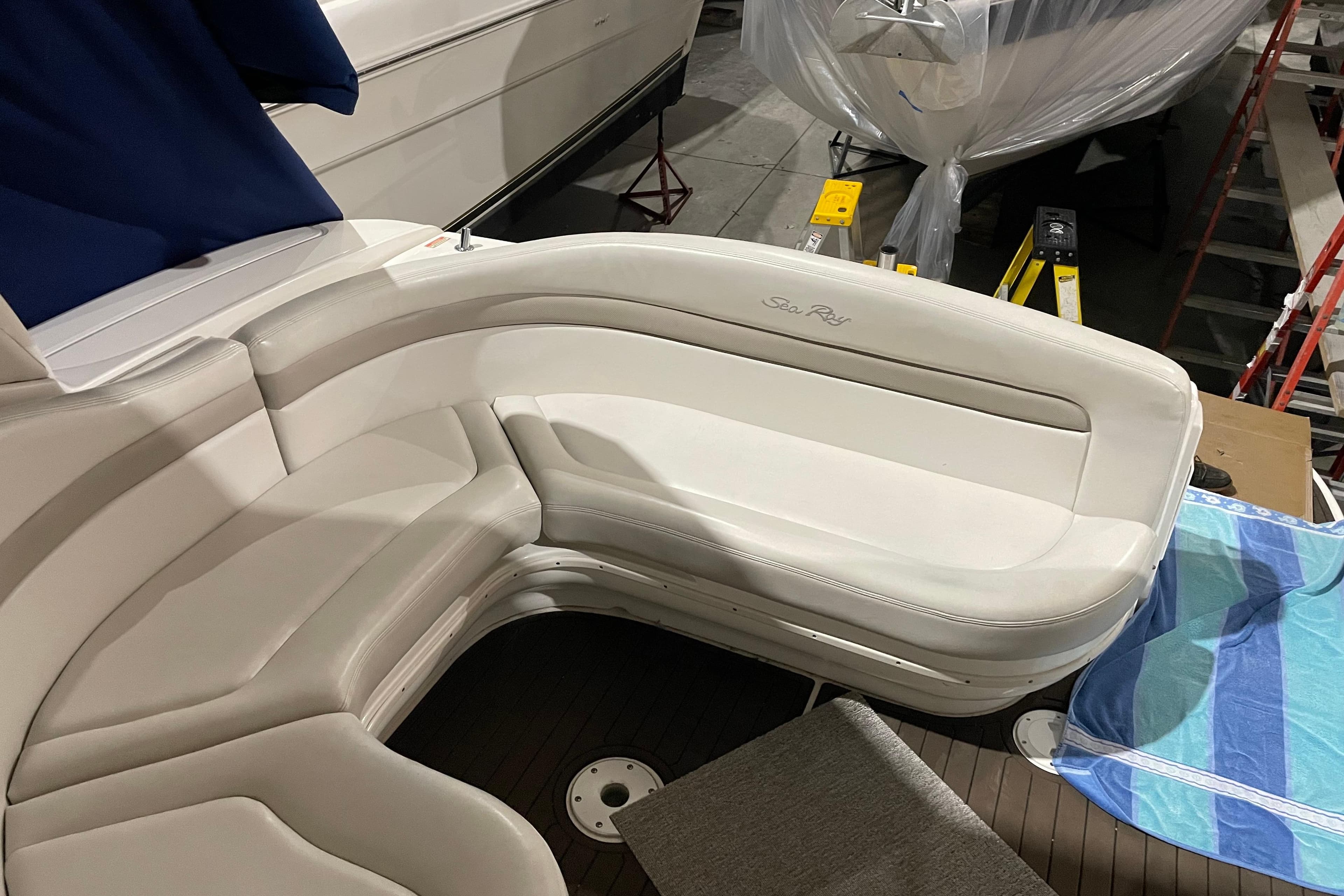 2002 Sea Ray Sundancer 320 boat interior with white seating and blue towel.