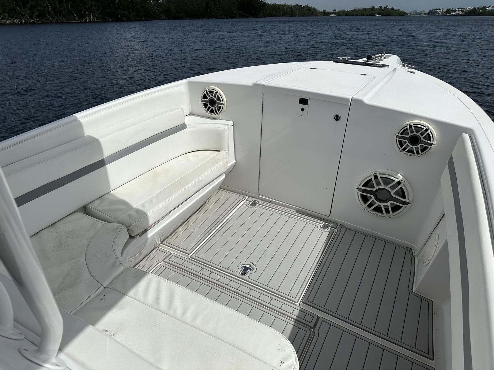 2003 Intrepid 32 boat interior with white seating and speakers on a calm lake.
