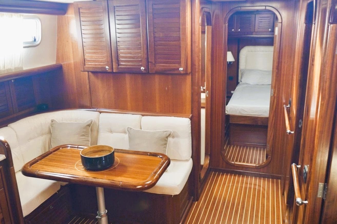 Luxurious 2006 Menorquin Yacht 180 interior with wooden finishes and cozy seating area.