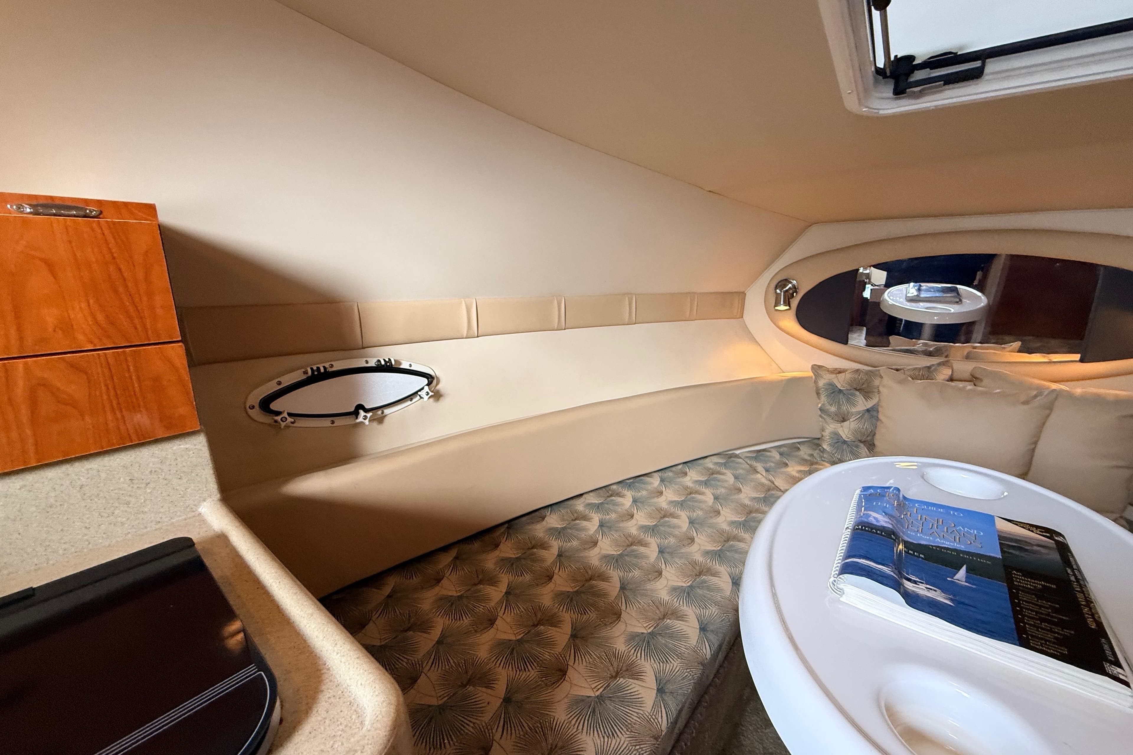 2007 Glastron GS 279 cabin interior with cozy seating and elegant wood accents.