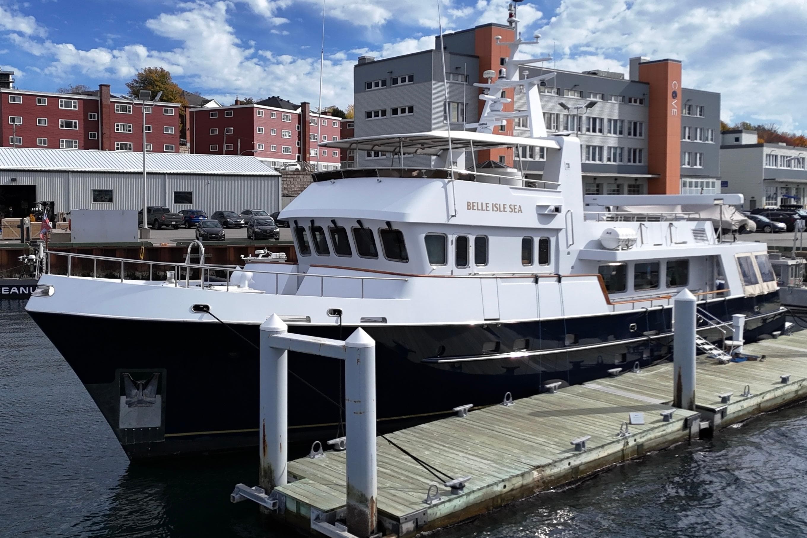 Luxury yacht "Belle Isle Sea" docked, Doogersbank Vipack 2001 model, with urban backdrop.