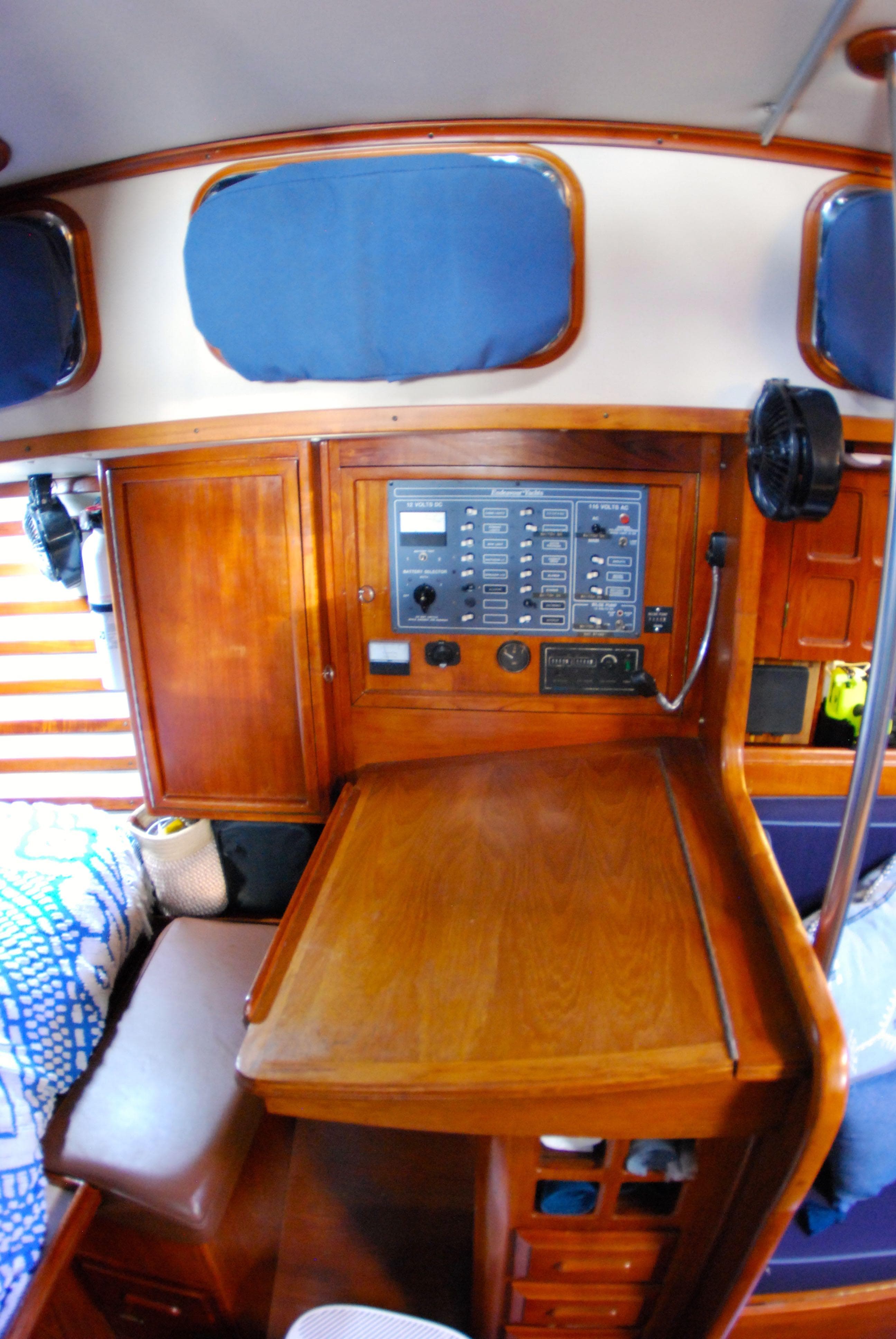 Interior of 1985 Endeavour 38 sailboat with wooden navigation station and control panel.