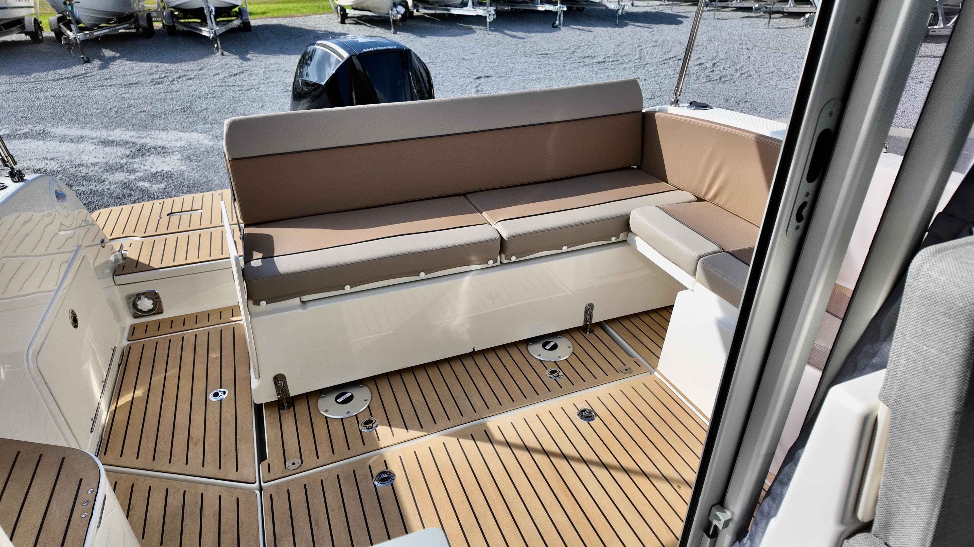2025 Bayliner TROPHY 25 EXPLORER boat interior with cushioned seating and teak flooring.