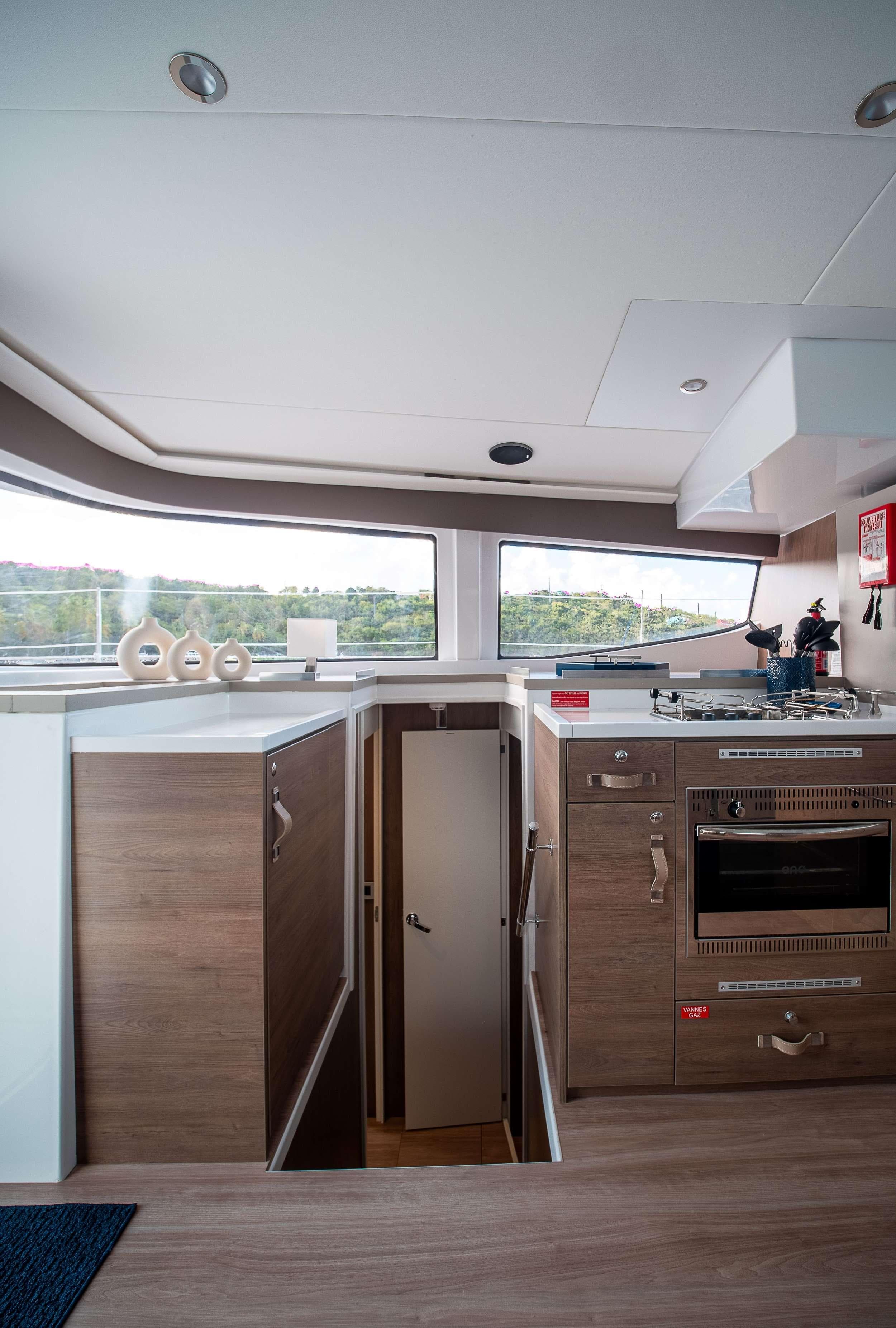 Modern kitchen interior on 2023 Bali 4.8 yacht with wood finish and appliances.