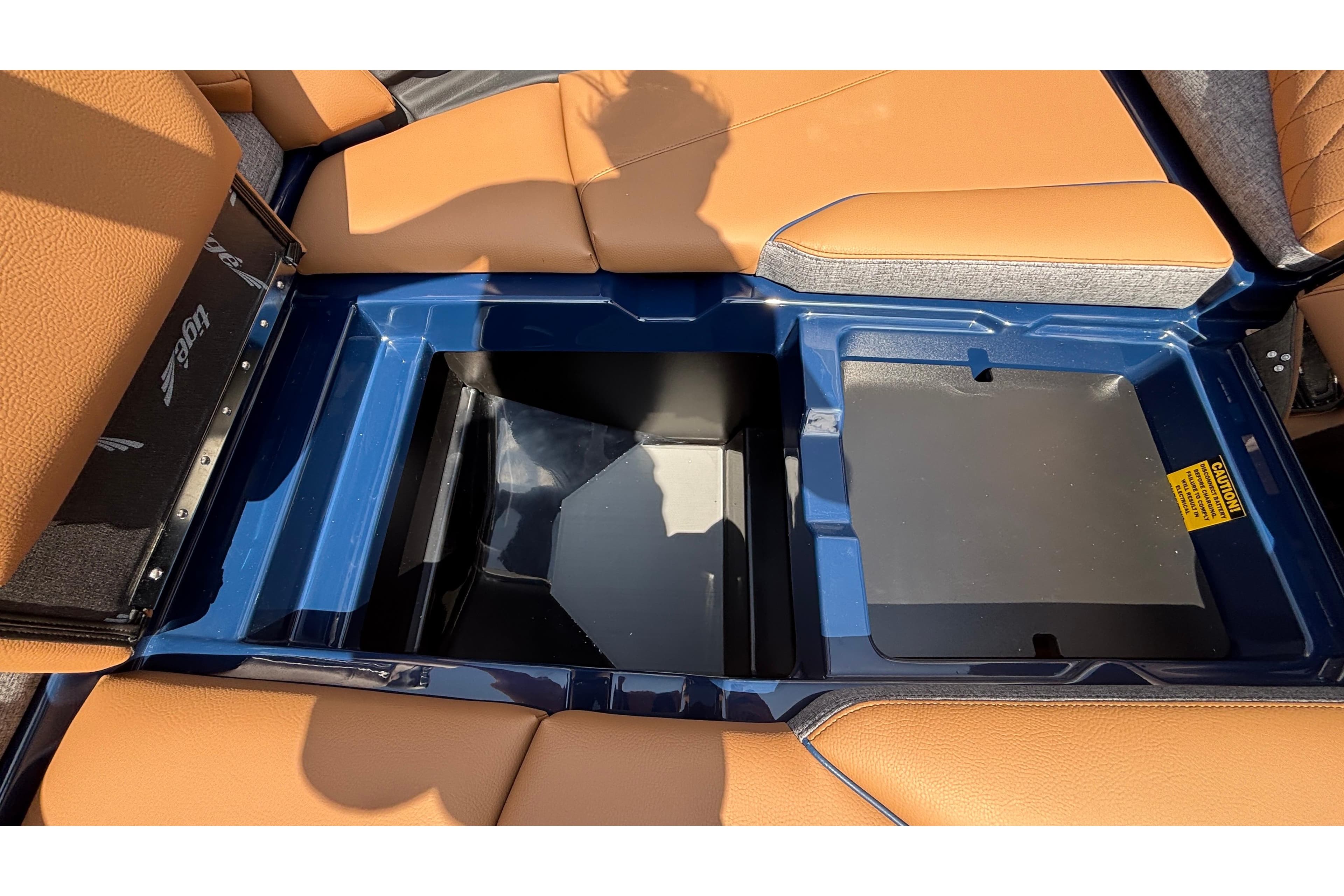 2026 Tigé Z3 boat interior storage compartment with tan seating and blue trim.
