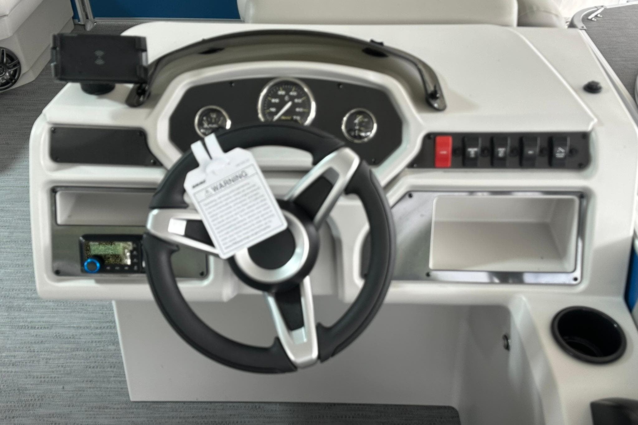 Steering console of 2026 Sweetwater EX2086SFLX boat with gauges and controls.