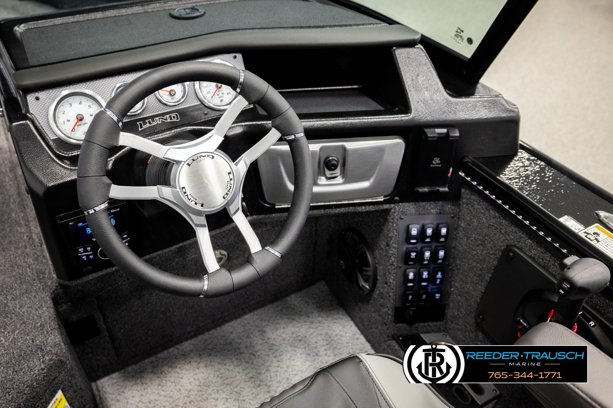 Interior of 2026 Lund 1975 Pro-V Sport boat with steering wheel and control panel.