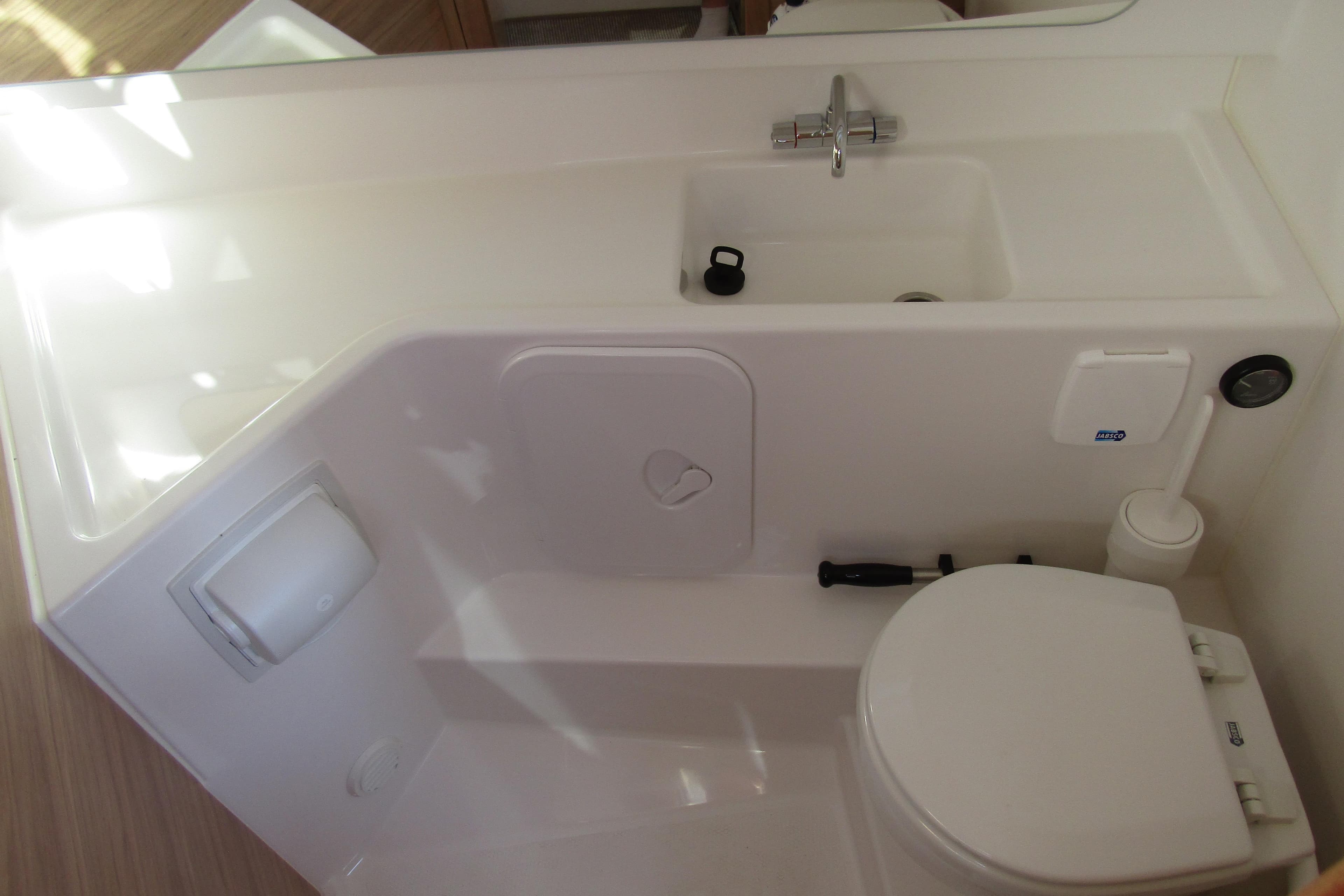 Compact bathroom in 2025 Nimbus Tender 9 boat, featuring sink and toilet.