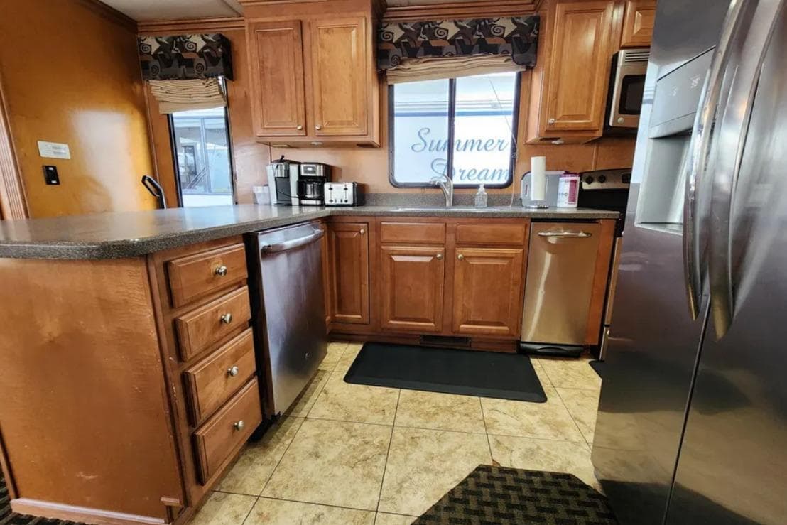 Kitchen interior of 2008 Sumerset Blue Moon Trip #11 houseboat, featuring wooden cabinets and stainless steel appliances.