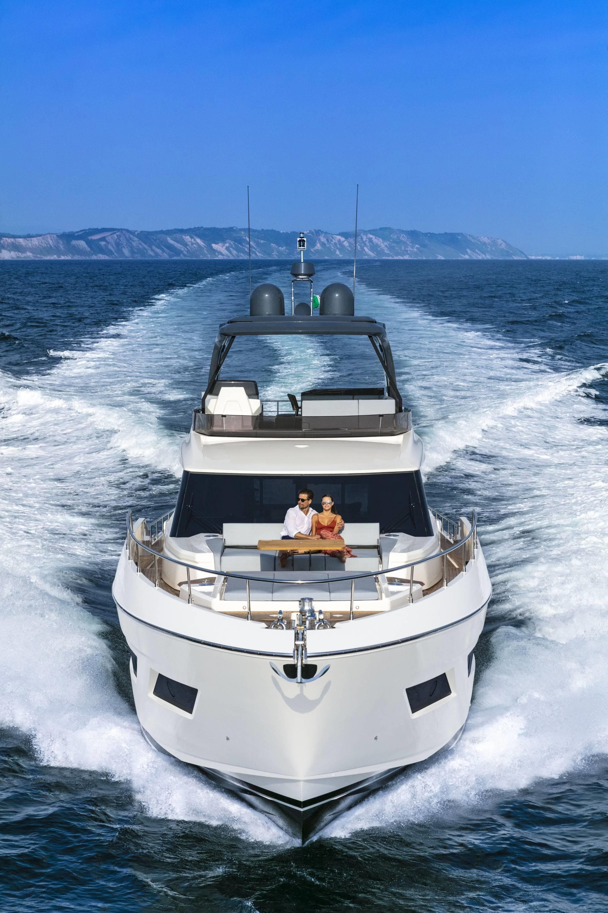2025 Ferretti Yachts 720 cruising on open sea with passengers on deck.