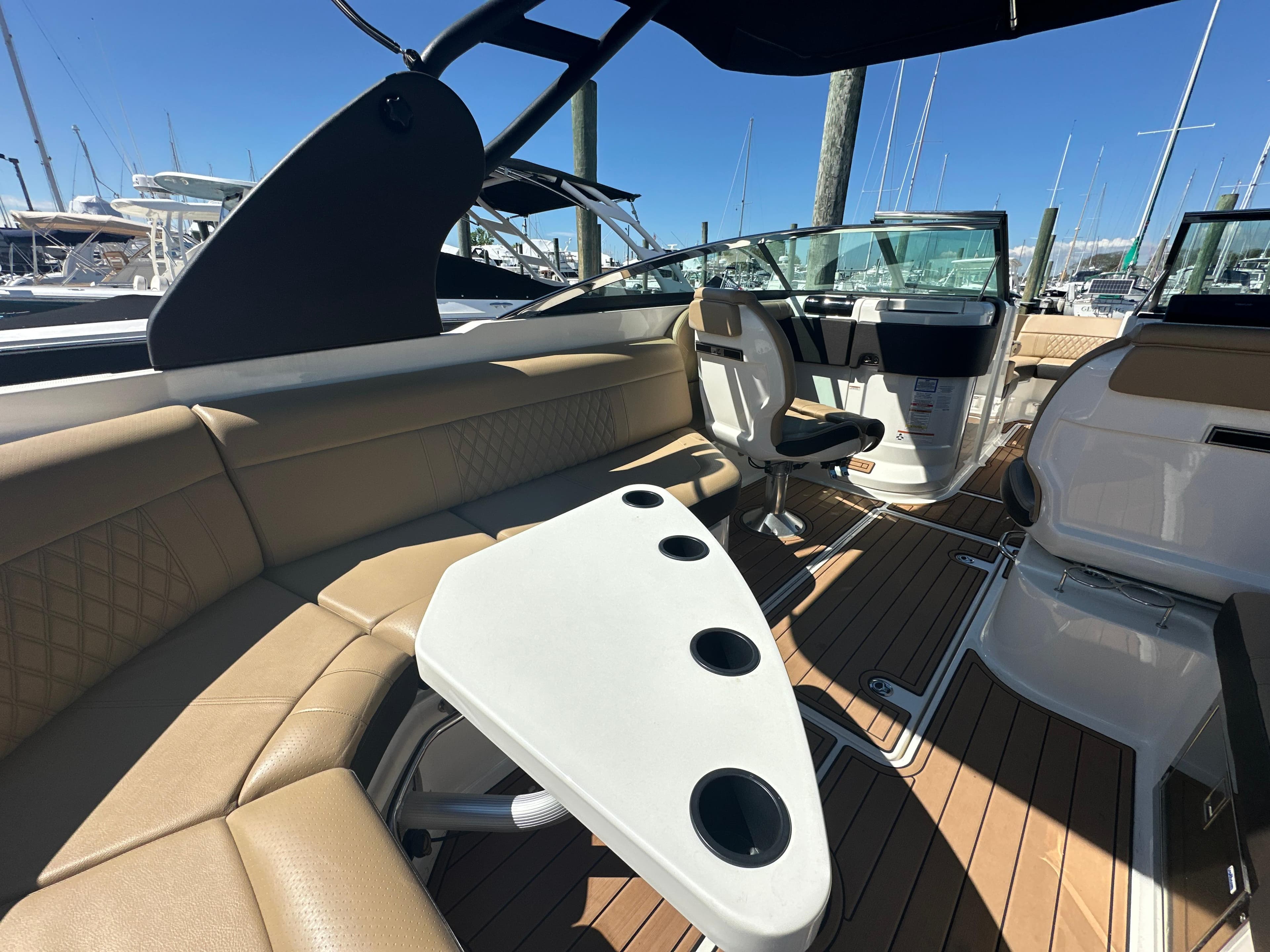 2019 Sea Ray SLX 280 interior with tan seating, white table, and wood flooring.
