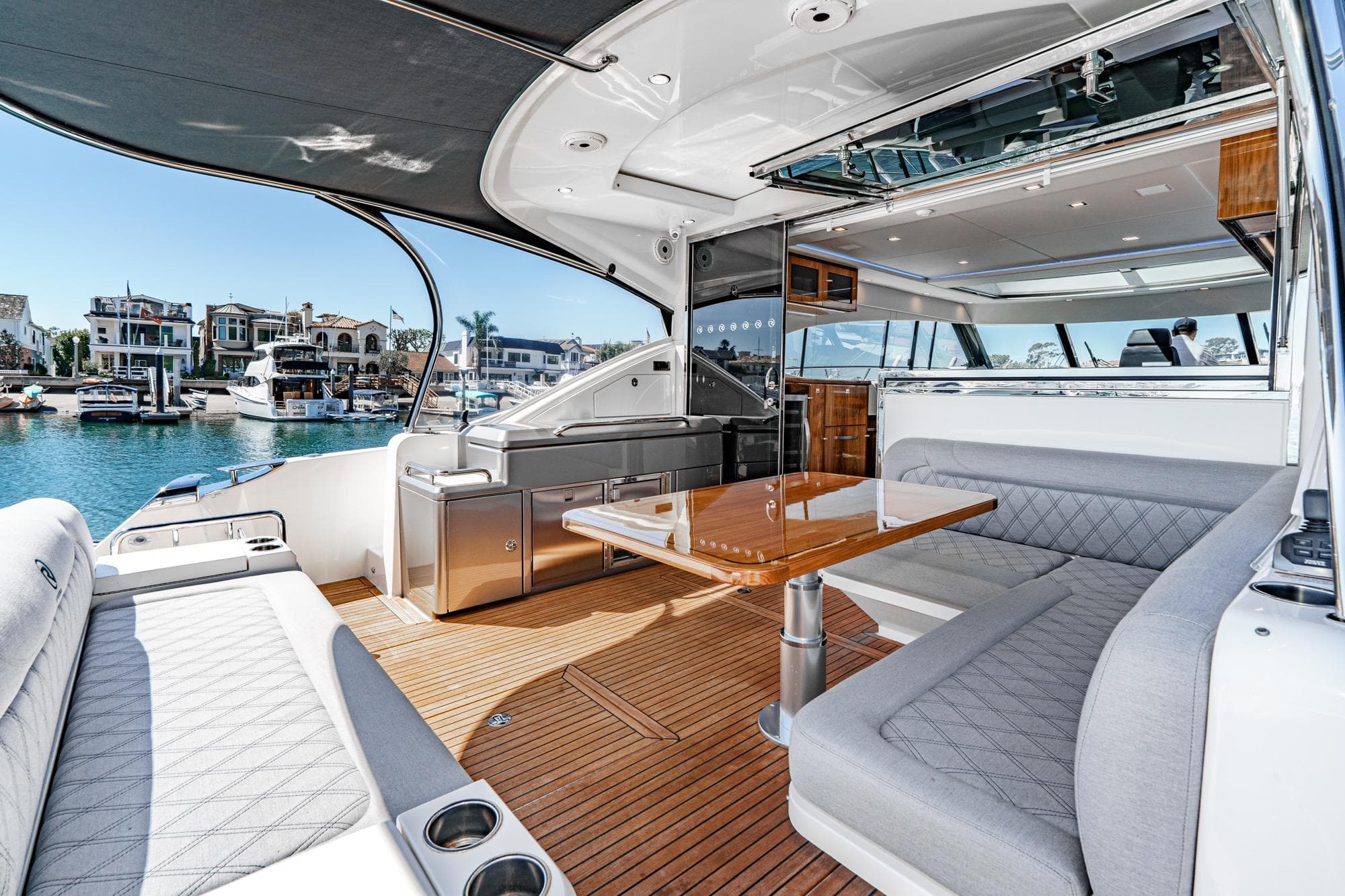 Luxurious 2024 Riviera 5400 Sport Yacht interior with elegant seating and waterfront view.