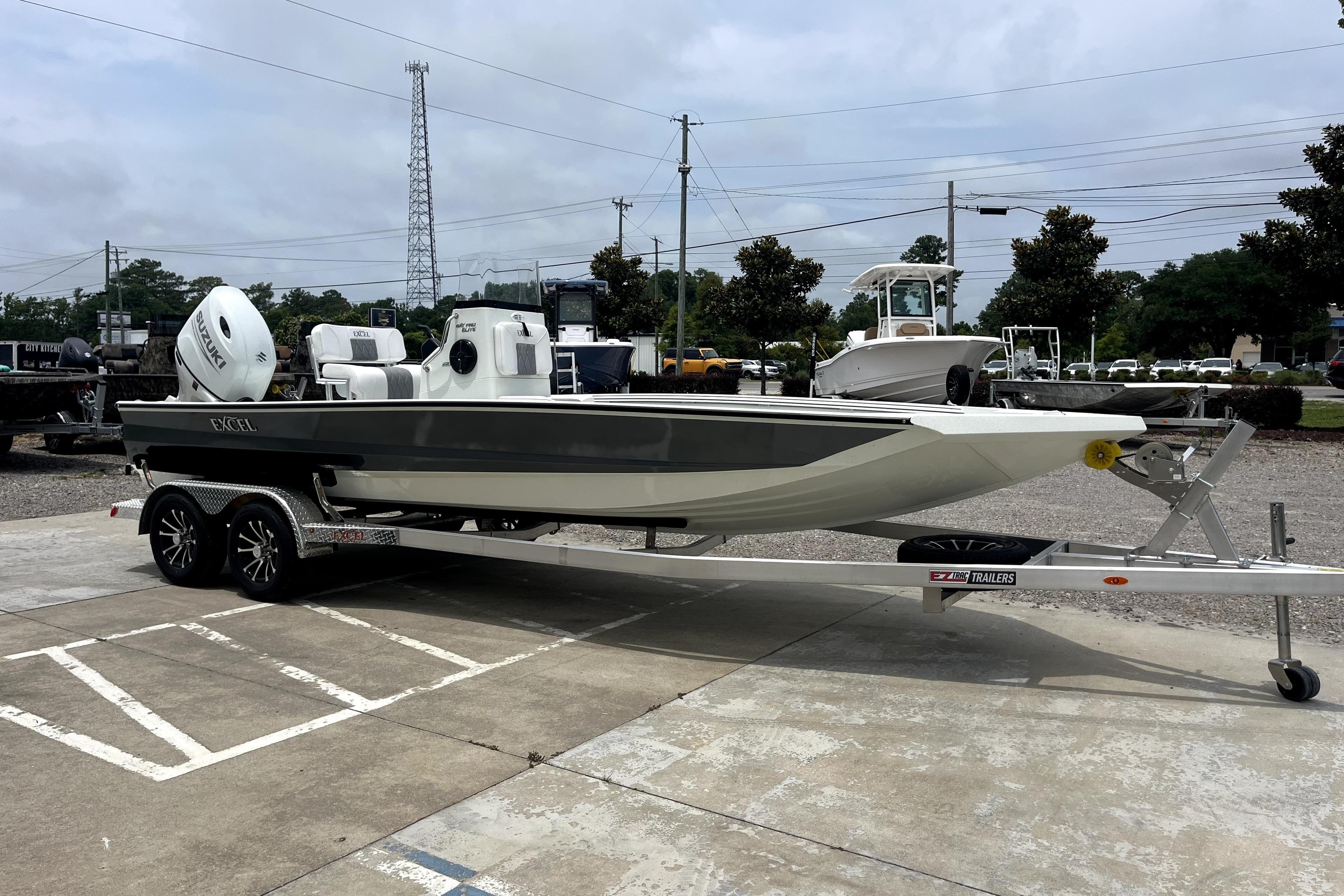 2026 Excel 220 Bay Pro Elite boat on trailer, parked outdoors, showcasing sleek design.