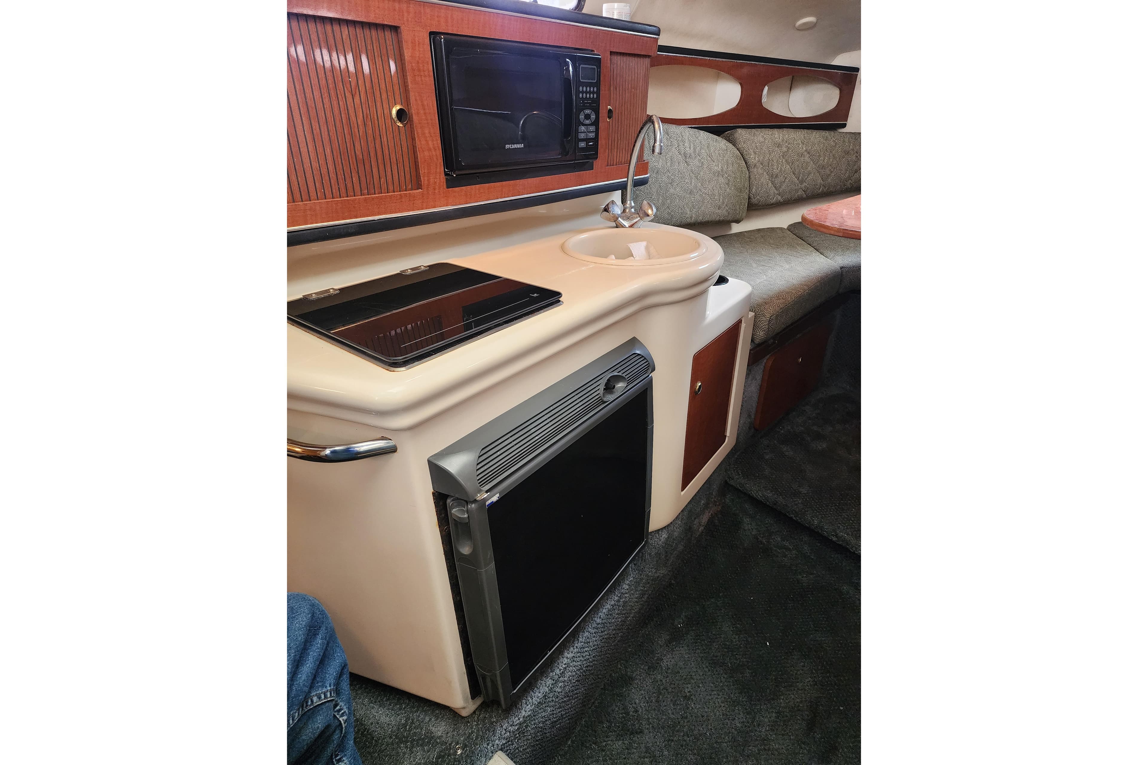 2003 Sea Ray Sundancer 260 cabin interior with kitchenette, sink, and seating area.